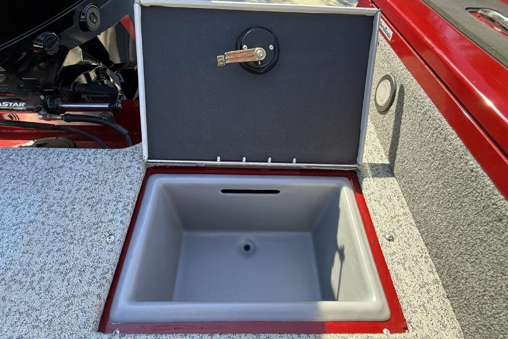 Open storage compartment on 2024 Tracker Targa V-19 WT boat, featuring red and gray interior.