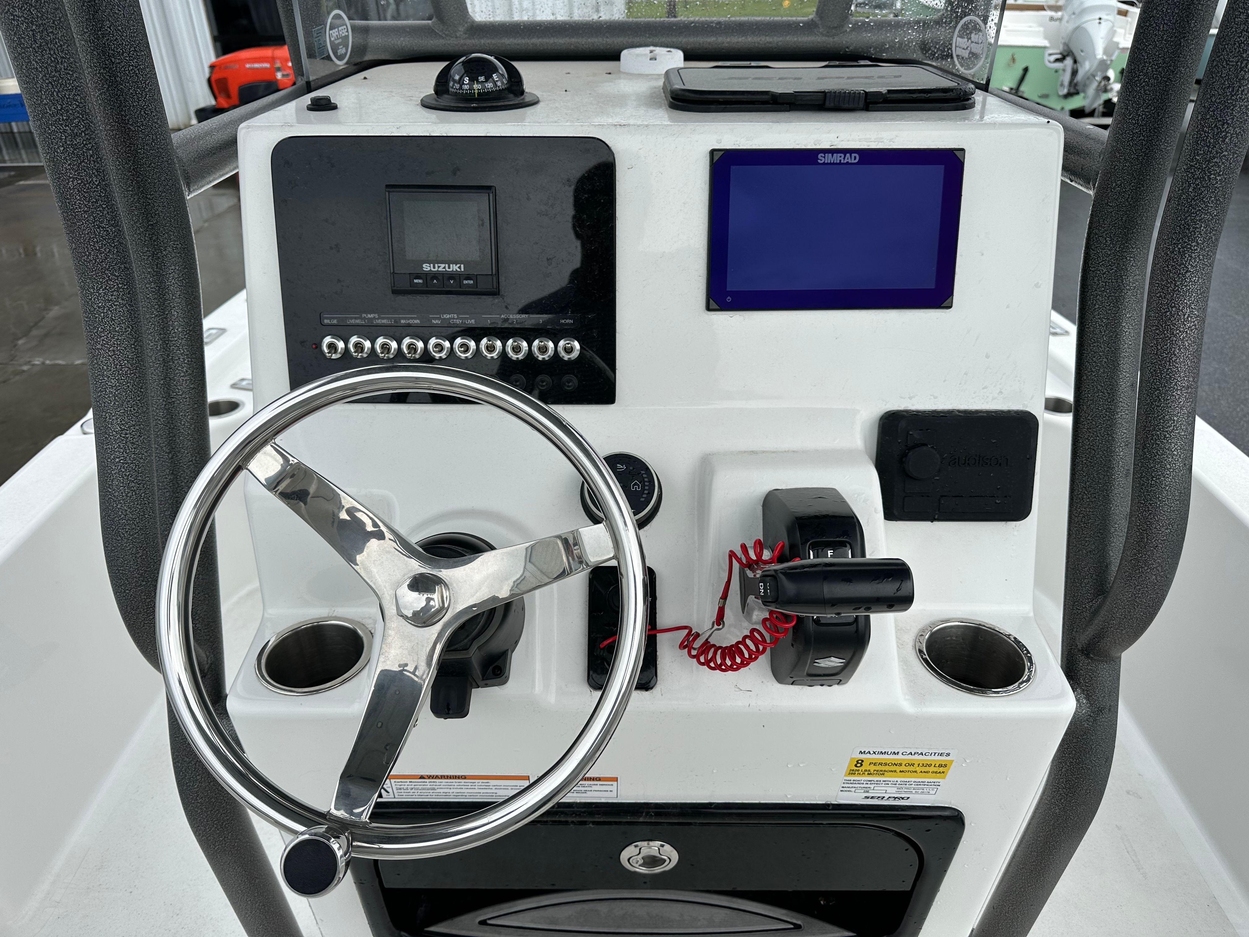 The image shows the helm of a Sea Pro 230 DLX boat with modern instruments.