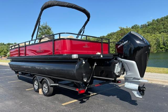 2025 Regency 250 DL3 pontoon boat with Mercury outboard, parked near a lake.