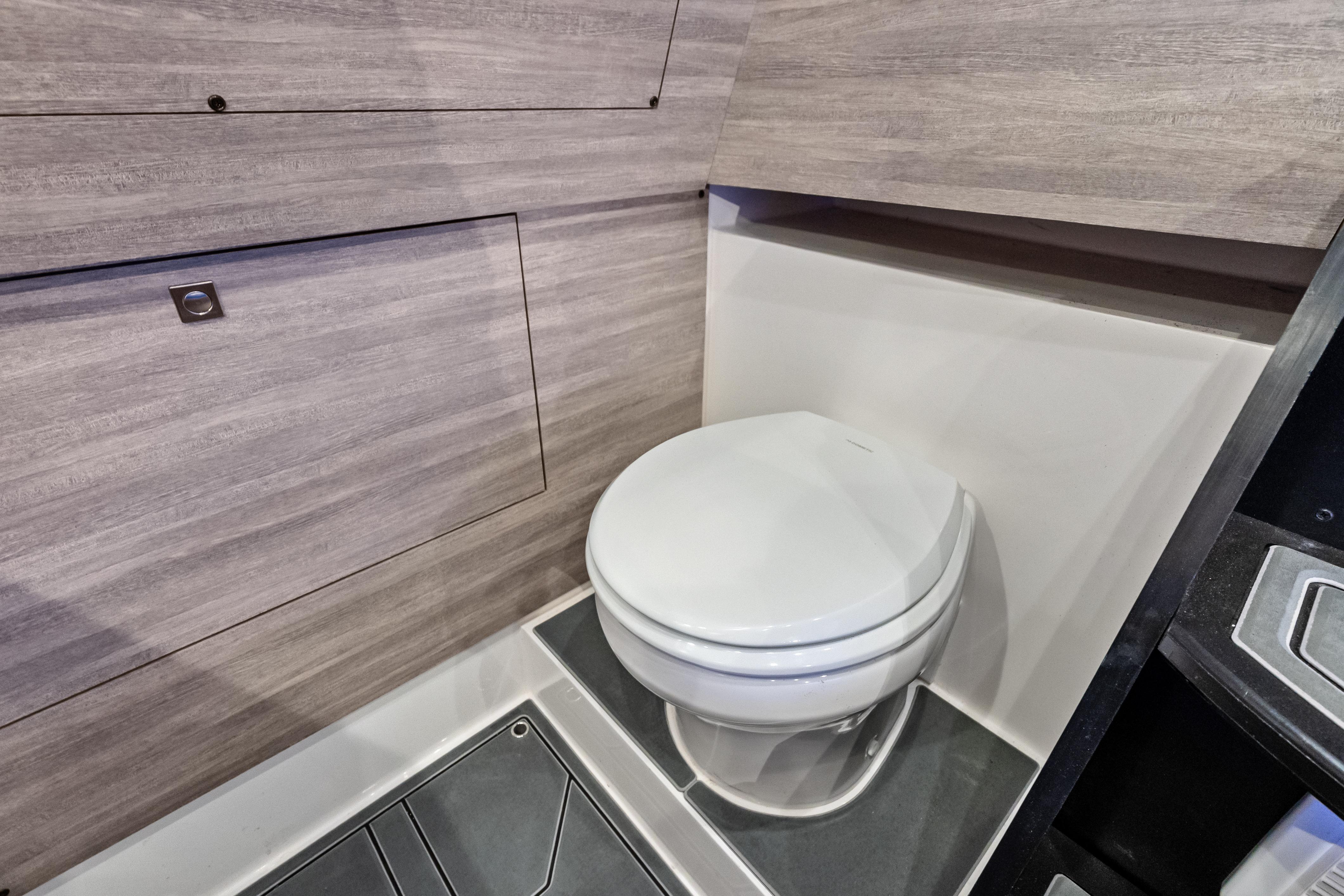 Modern bathroom interior in 2027 Mystic Powerboats M4200, featuring sleek design and compact toilet.
