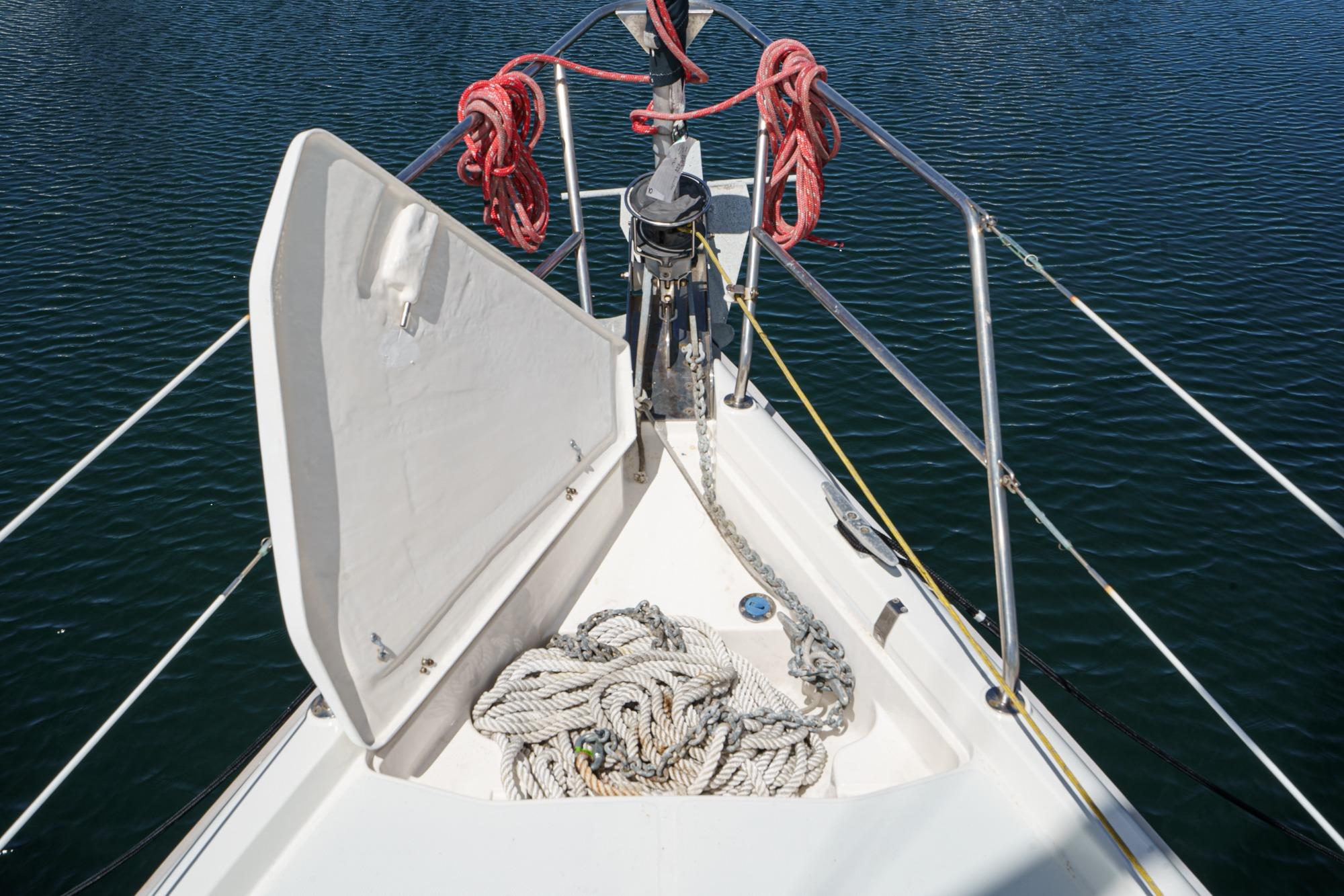 Bow of a 1996 Hunter 376 sailboat with ropes and anchor chain.