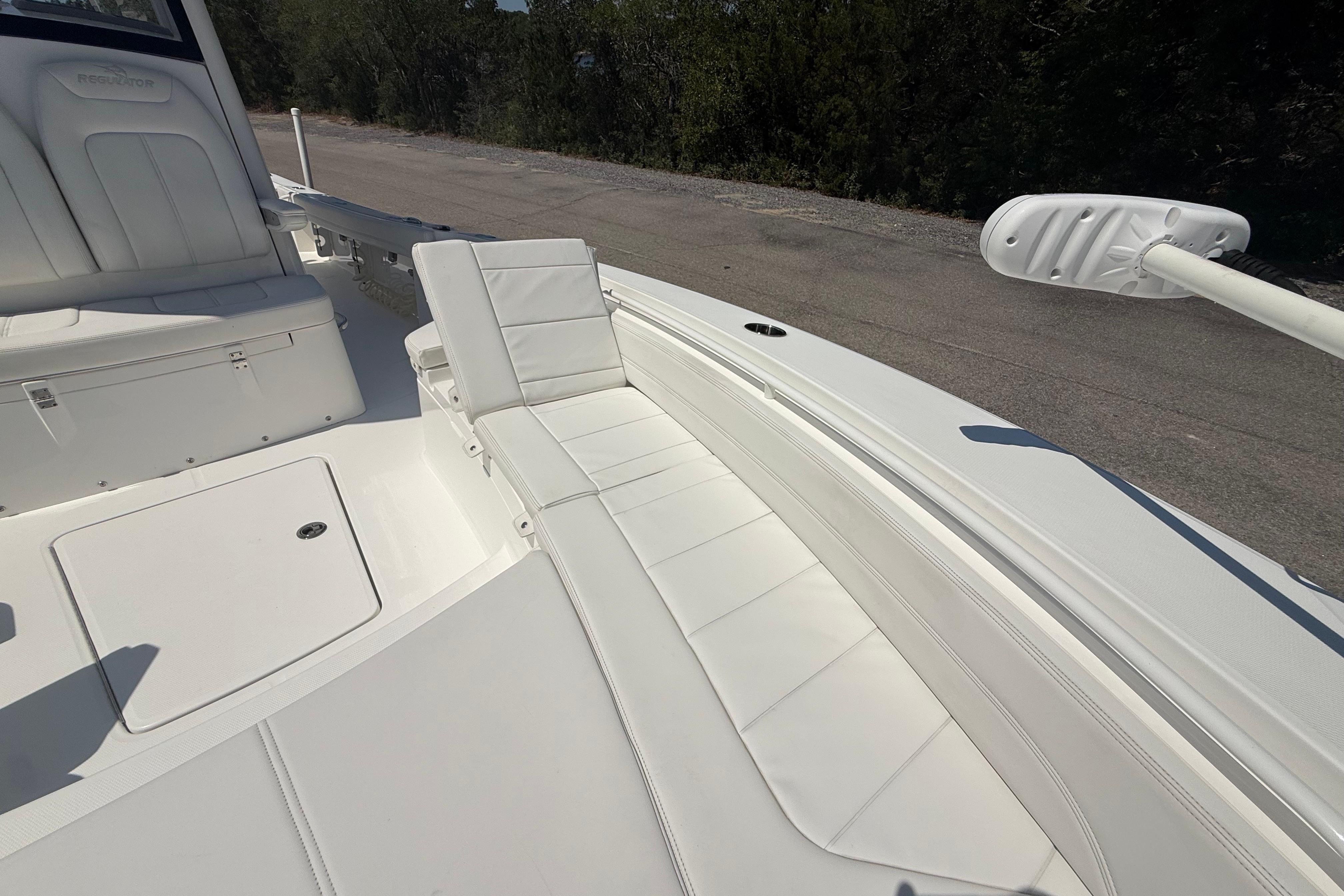 2023 Regulator 26XO boat interior with white cushioned seating and storage compartments.