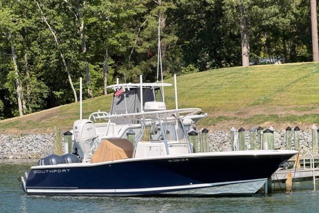 2014 Southport 29 FE boat docked by a grassy shoreline with trees.