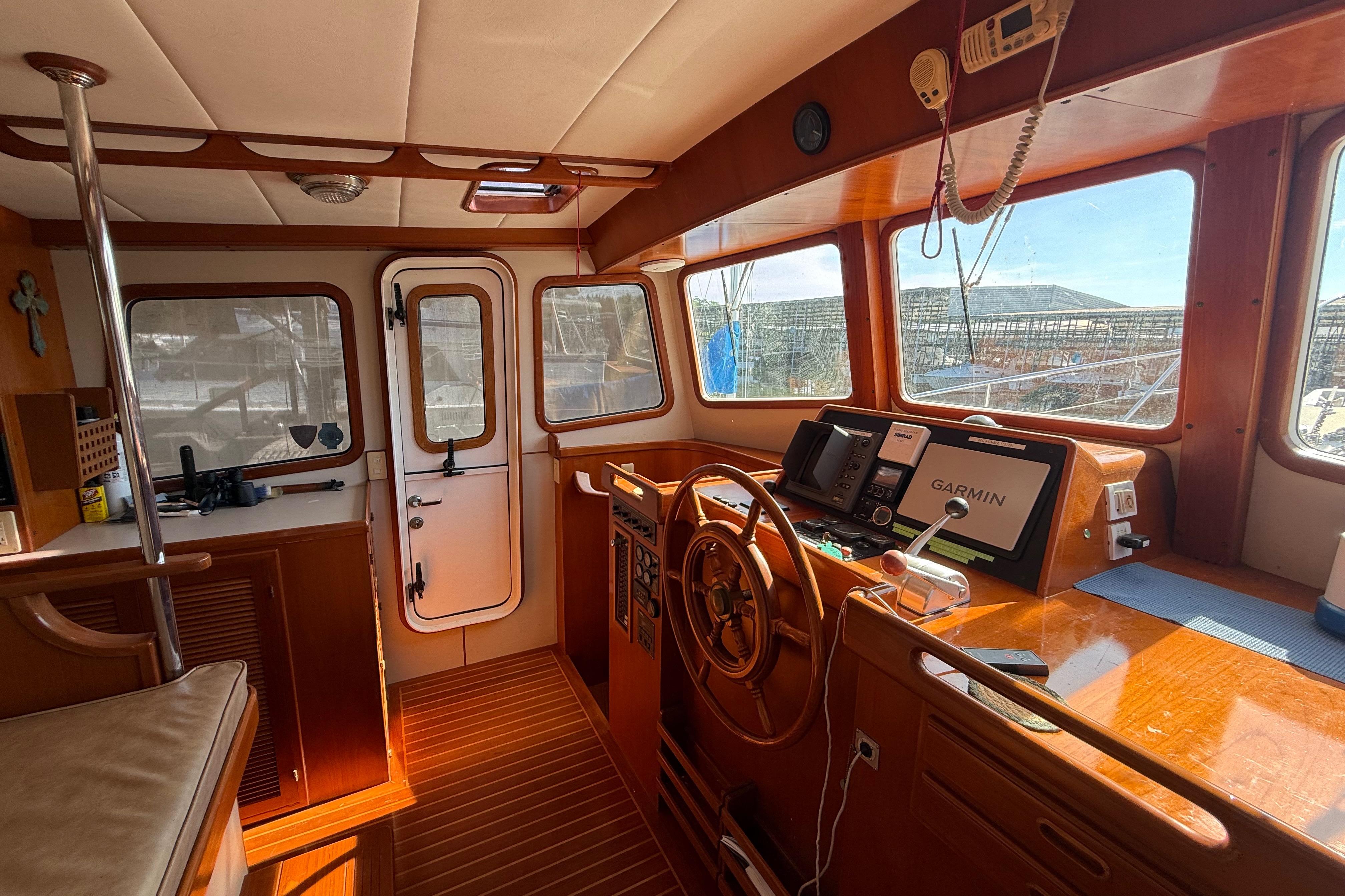 Interior of 2001 Kadey-Krogen 39 boat with wooden helm and Garmin navigation system.