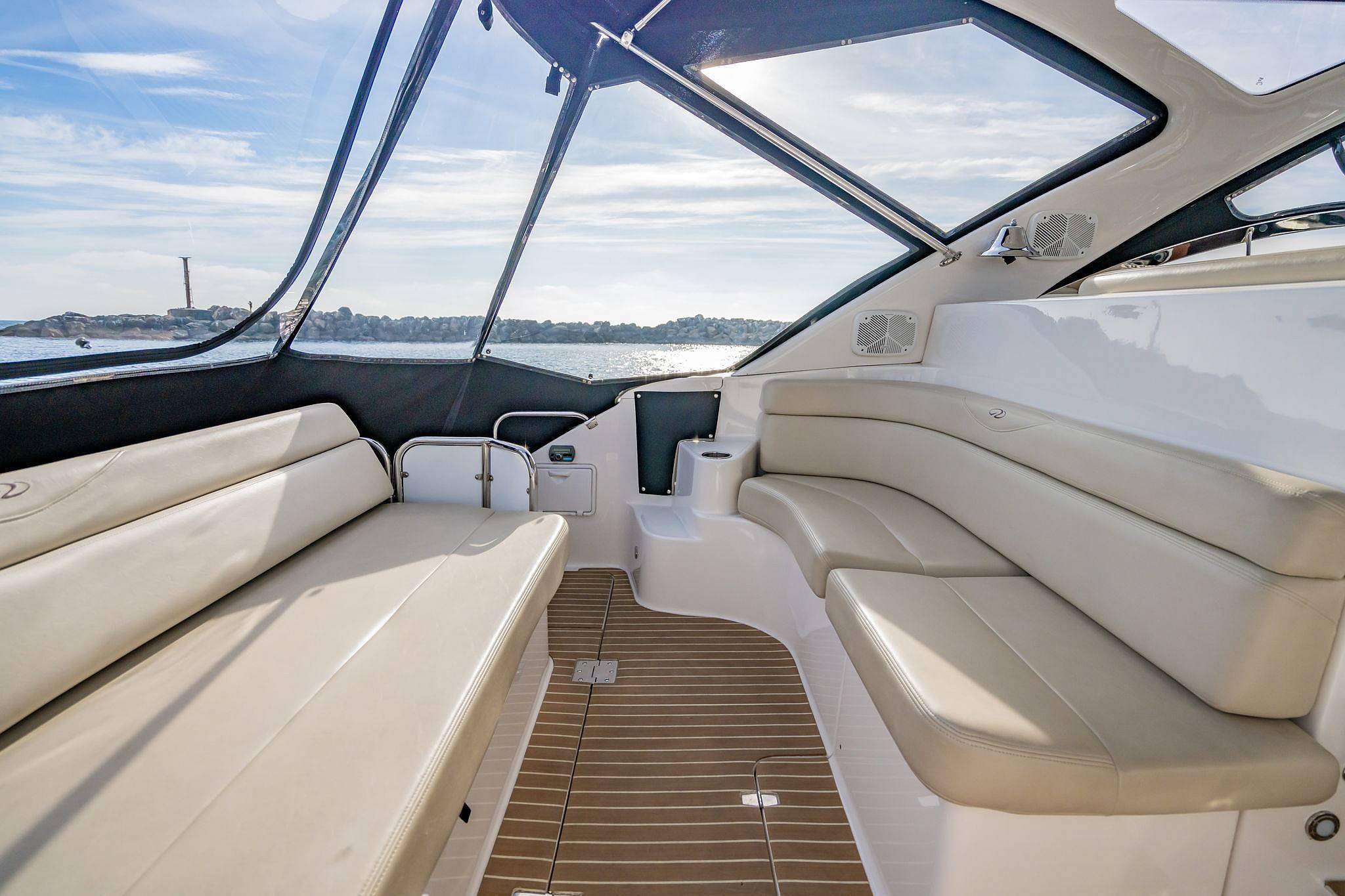 Luxurious interior of 2010 Regal Commodore 4460 yacht with beige seating and panoramic windows.