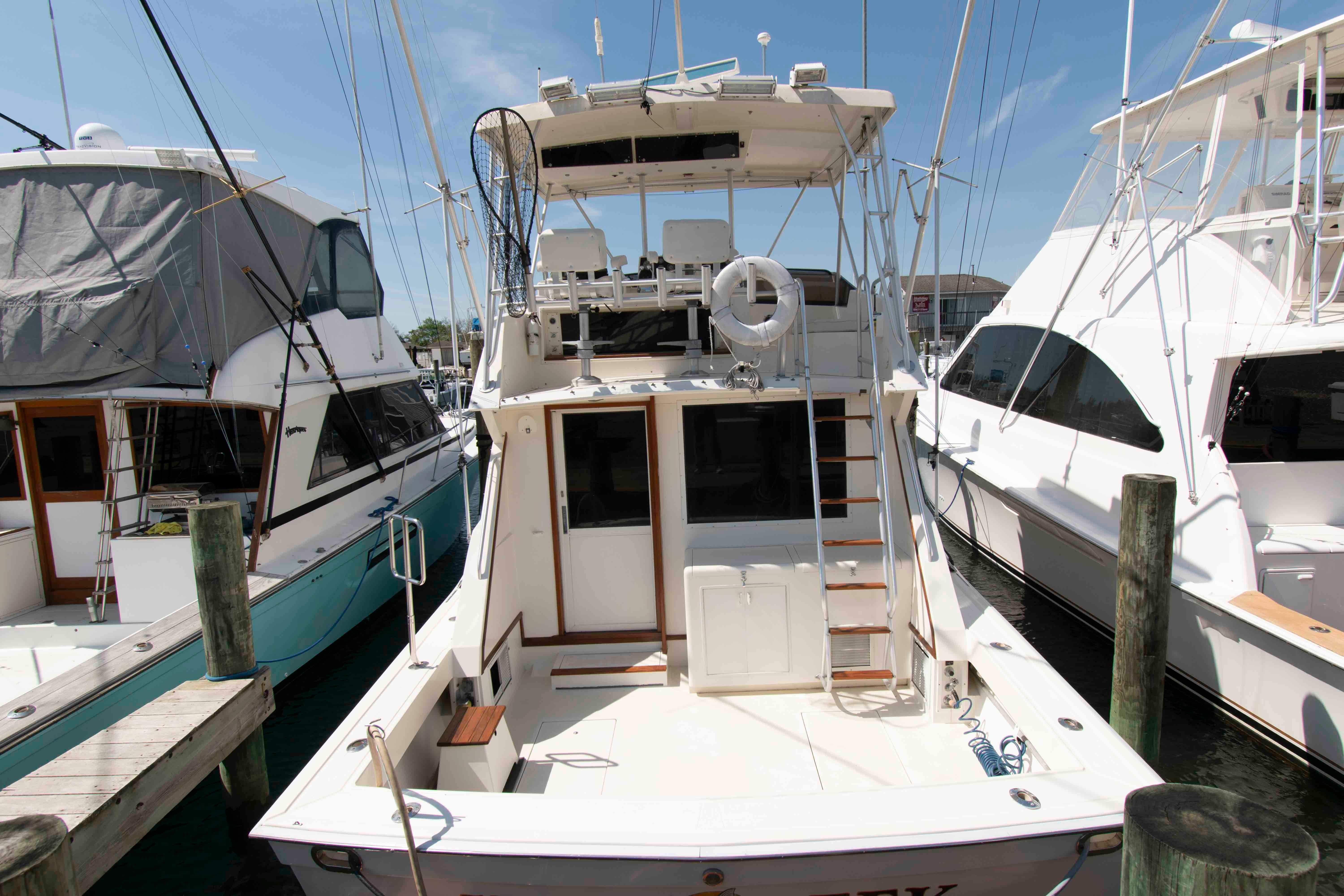 1988 Viking 41 Convertible yacht docked at marina, rear view showing deck and ladder.