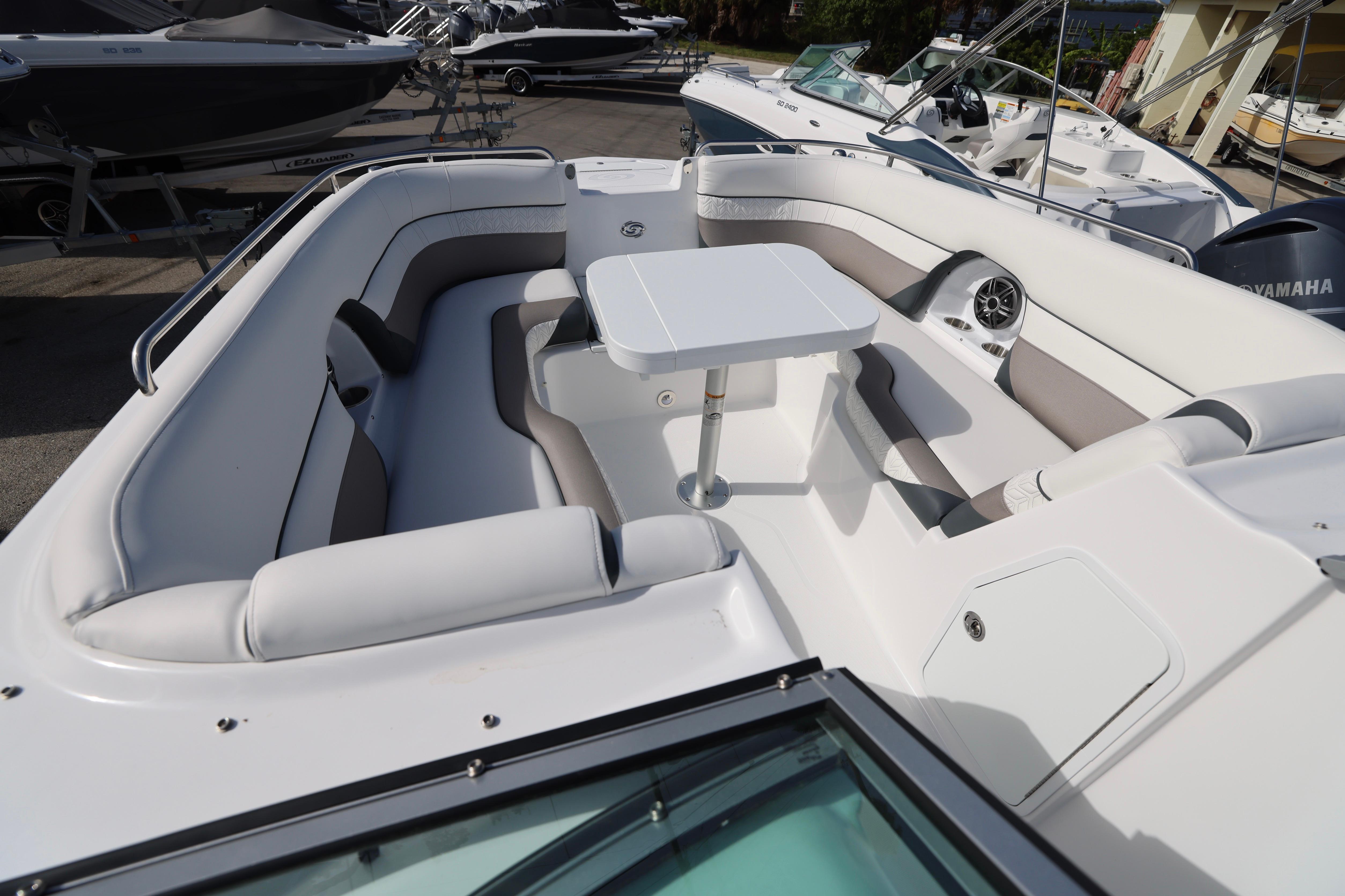 2026 Hurricane SunDeck 2486 OB boat interior with seating and table, showcasing luxury design.