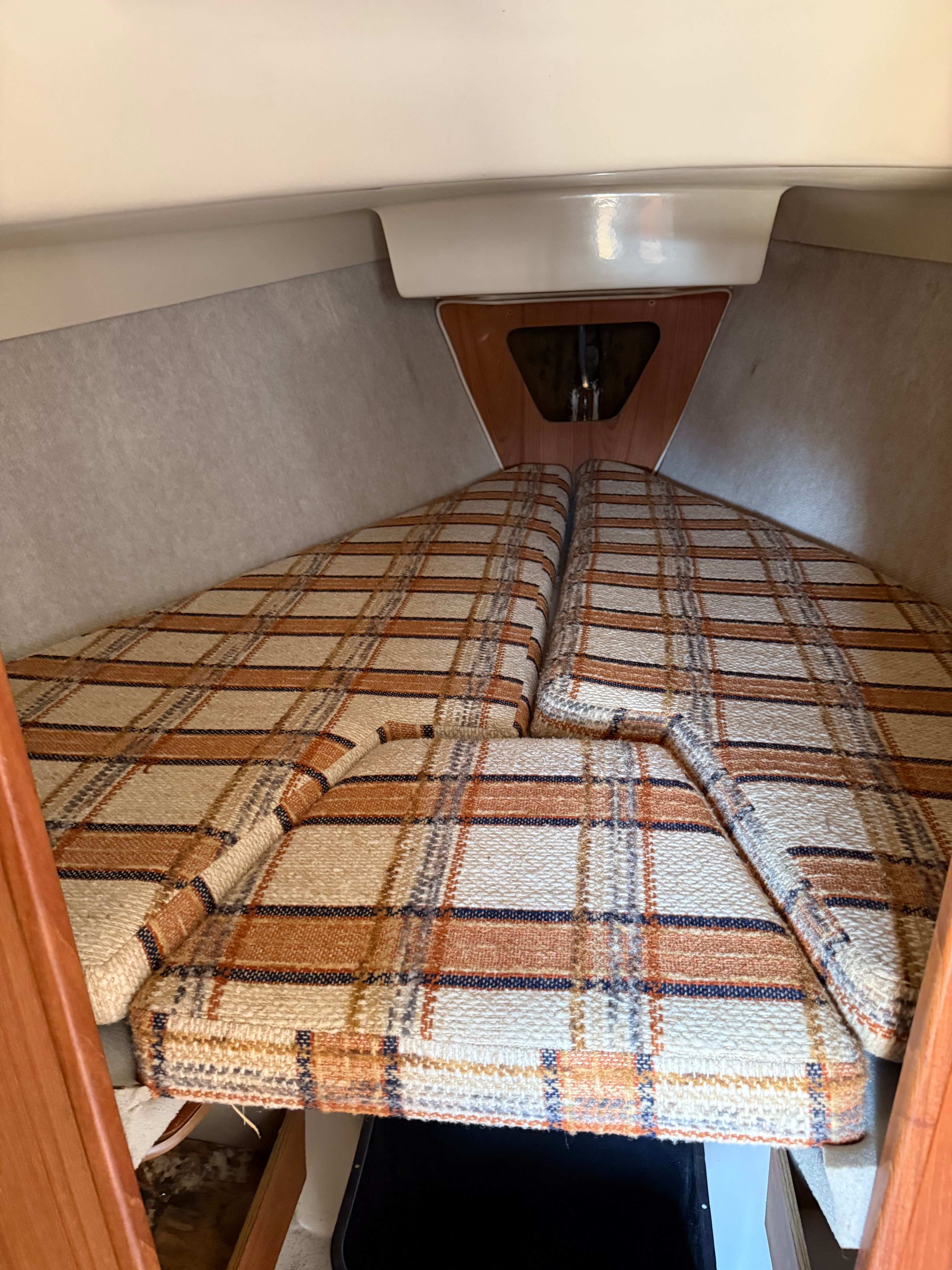 Interior of a 1984 O'Day 25 with plaid upholstery.