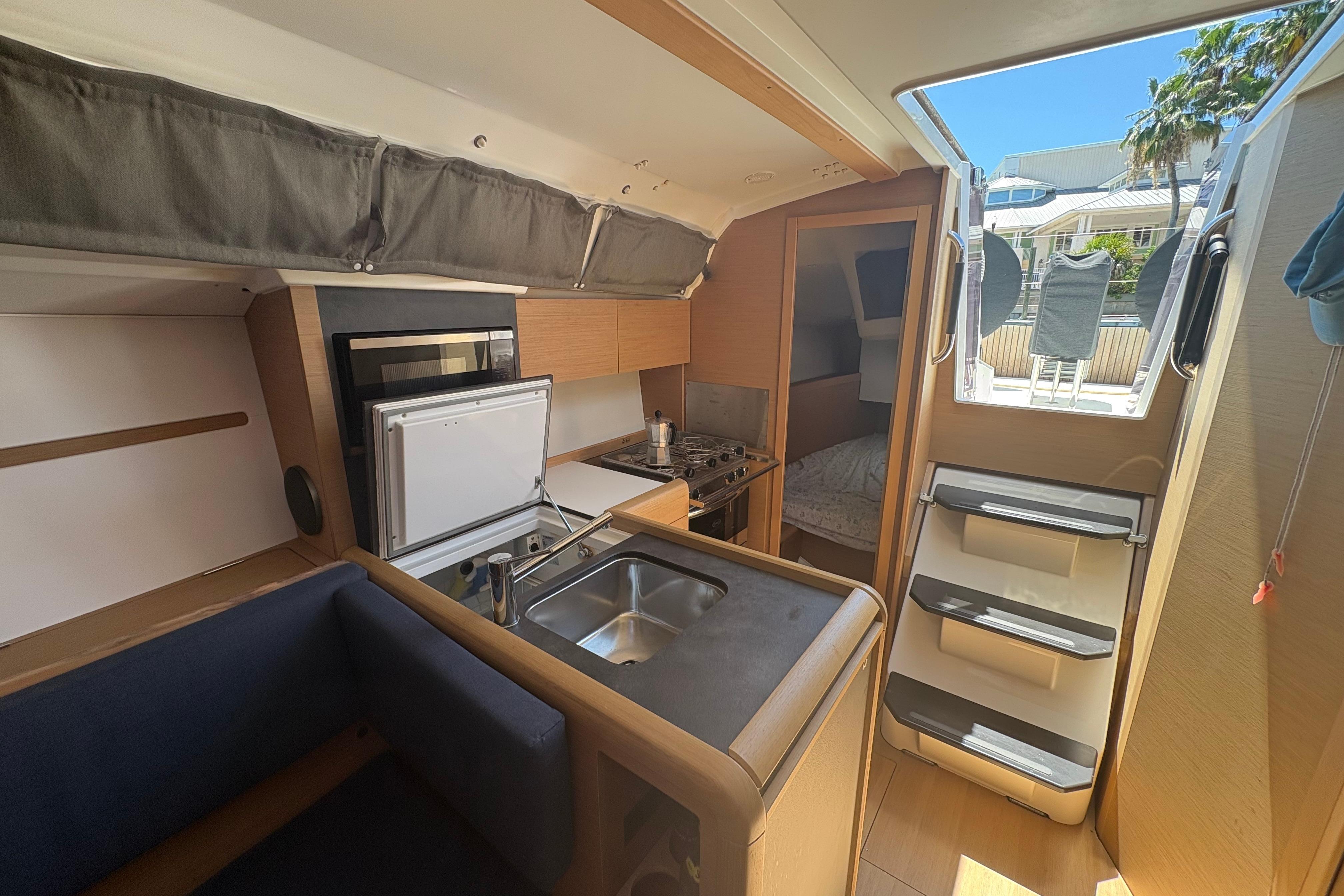 Interior of 2021 Jeanneau Sun Odyssey 349 sailboat, featuring compact kitchen and cozy cabin space.