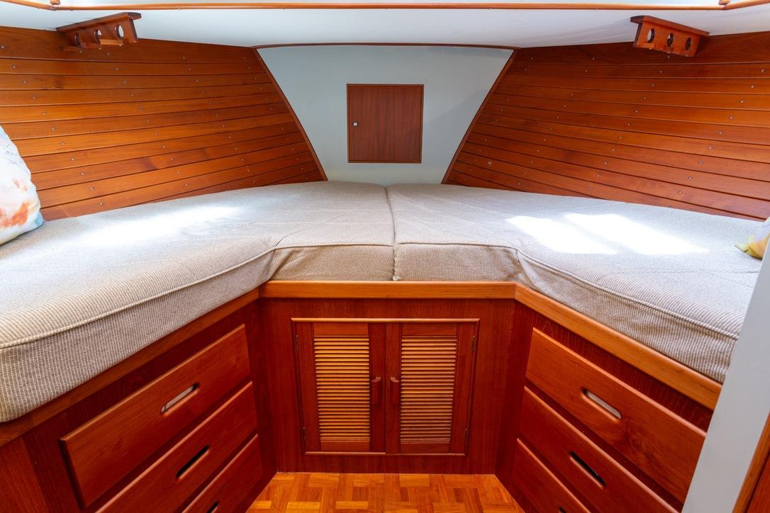Cozy cabin interior of 1993 Grand Banks 46 Motoryacht with wooden finish and storage drawers.