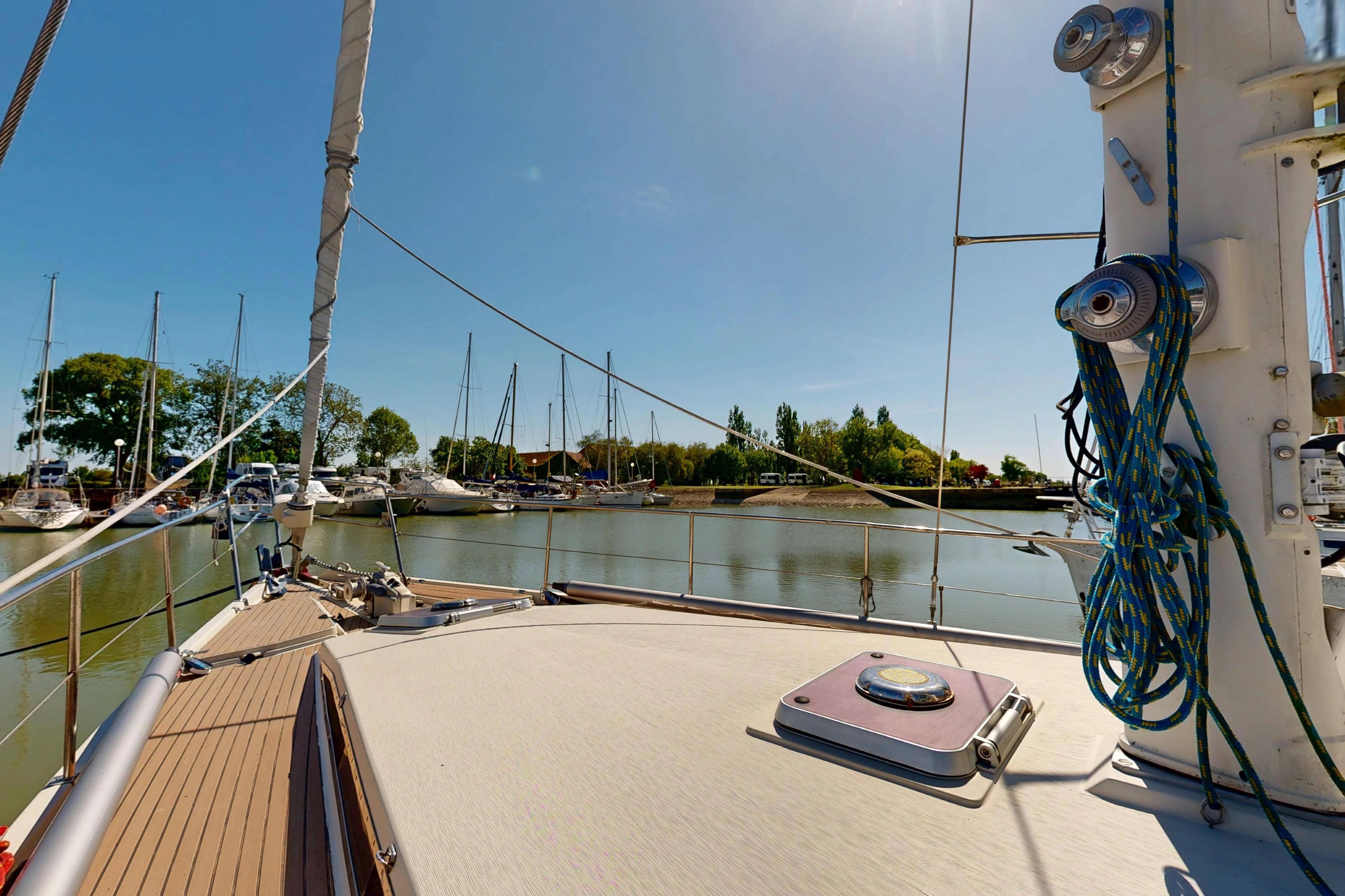 Sailing yacht Amel Super Maramu 2000, 1999 model, docked in a serene marina.