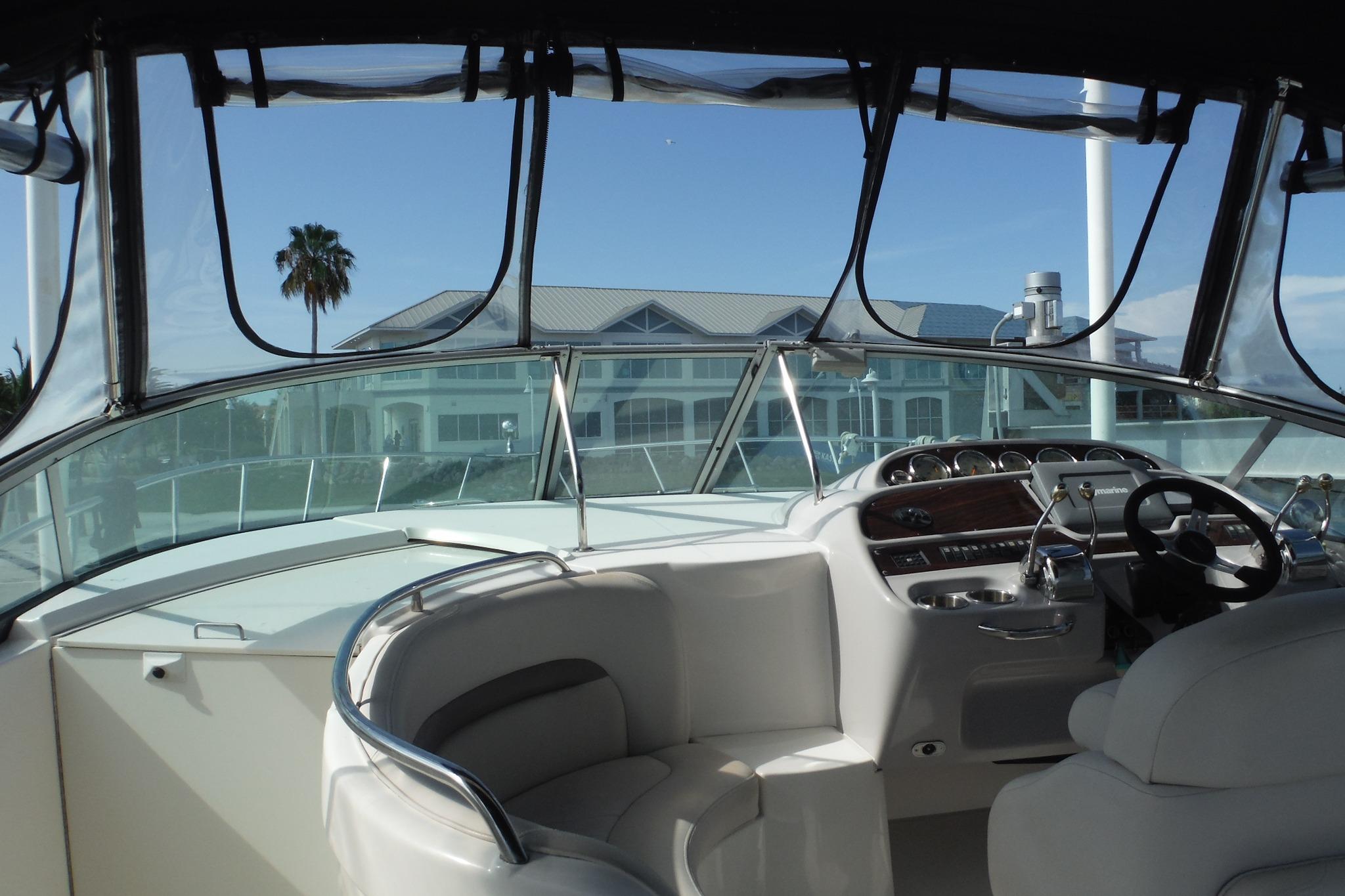 2005 Chaparral Signature 350 yacht interior with steering wheel and dashboard, overlooking waterfront property.