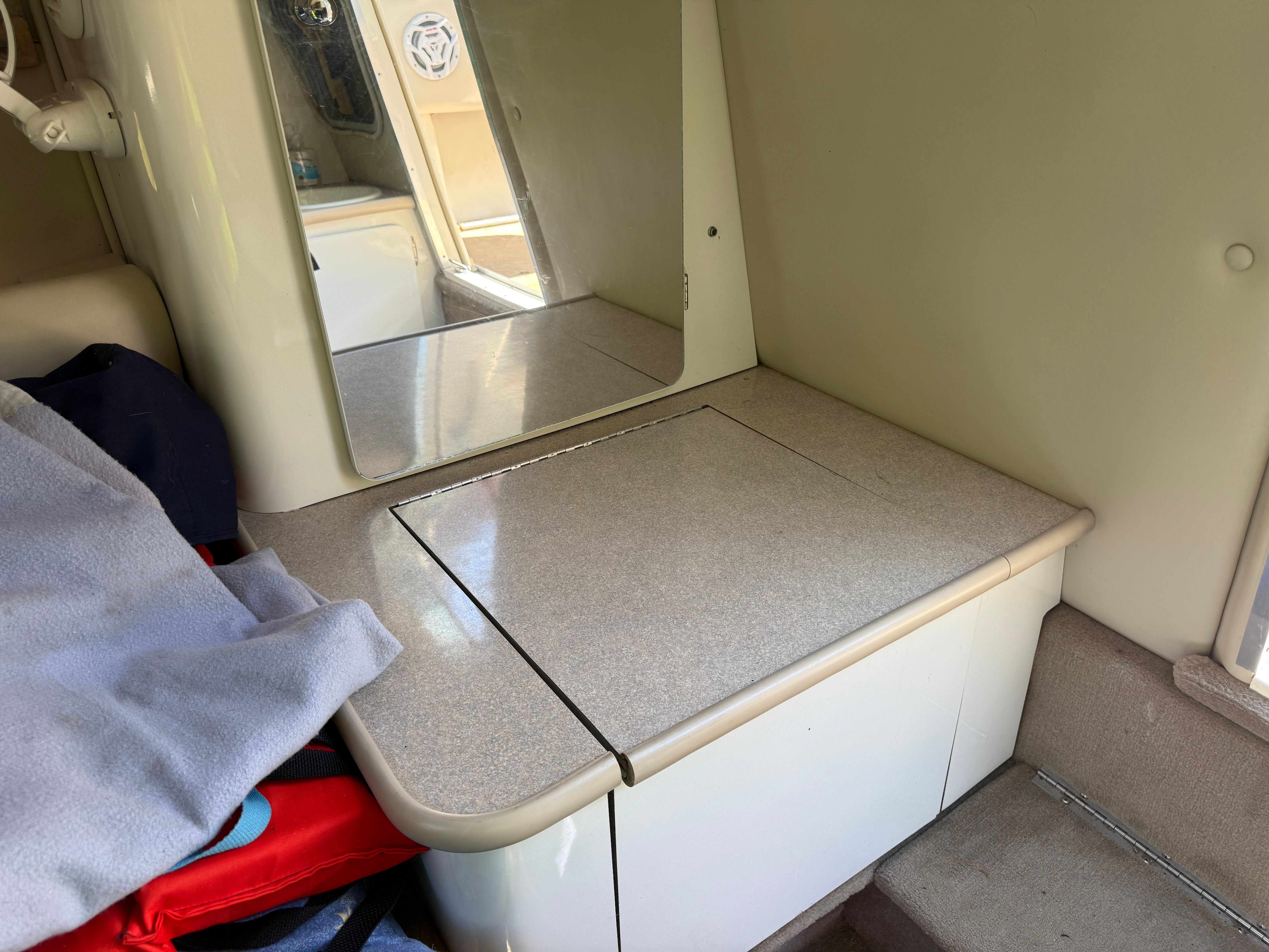 Interior of a 1999 Custom 2335 Cuddy cabin with mirror.