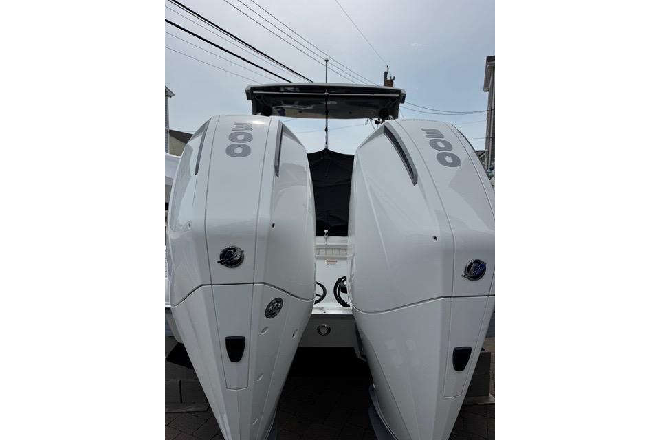 2023 Crownline Eclipse E305 XS boat with dual outboard engines, rear view.