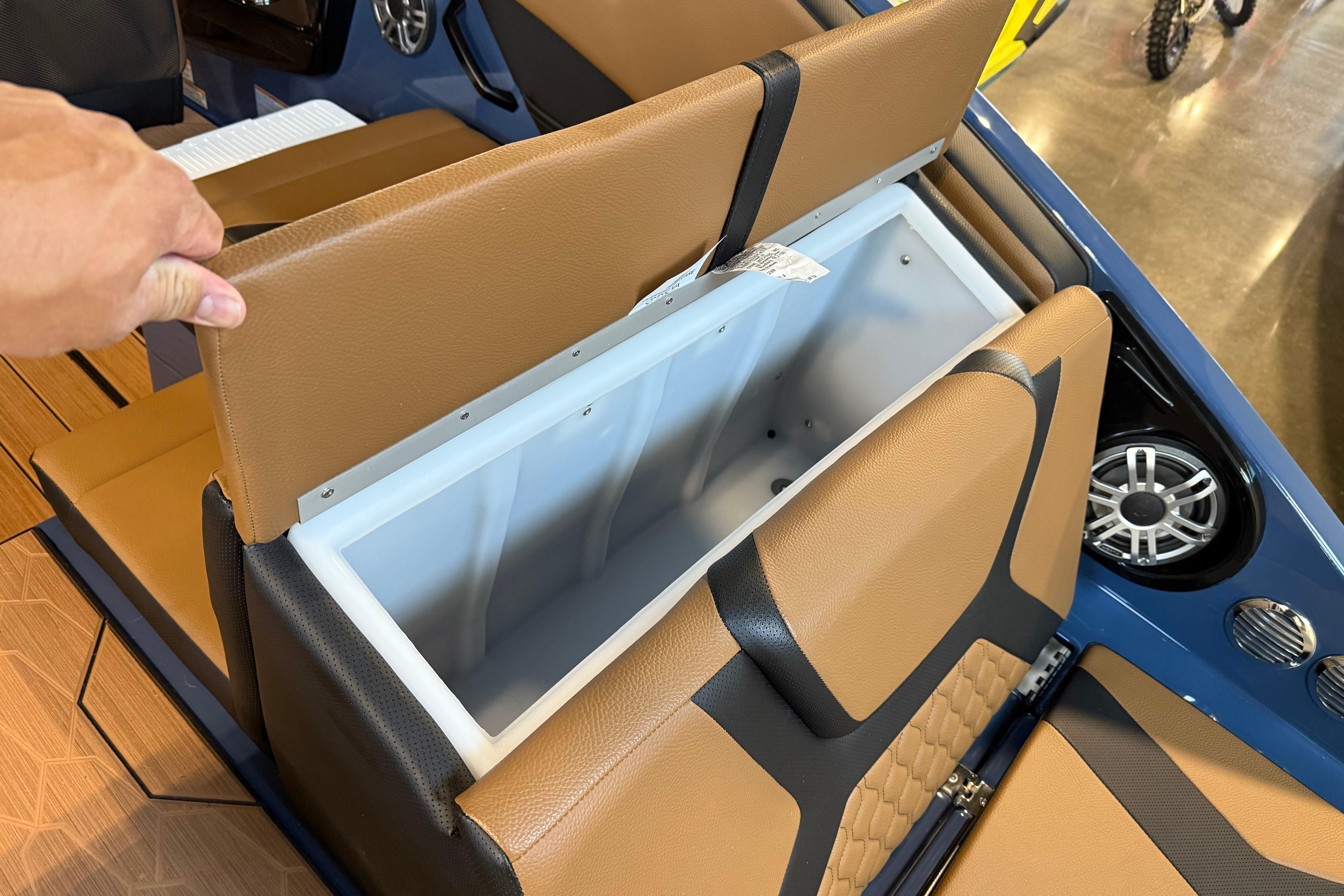 2026 Yamaha Boats 222XD seat storage compartment with brown upholstery and speaker detail.