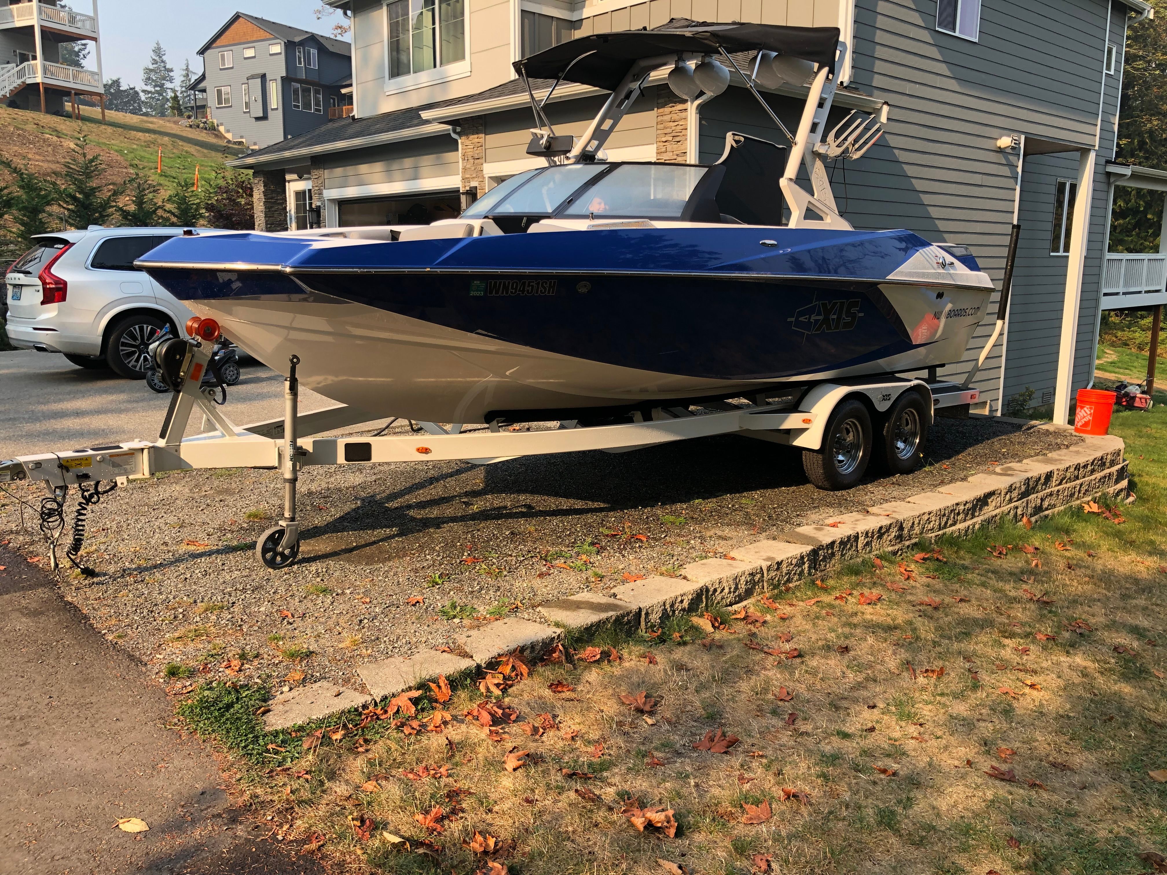 Blue Custom a22 boat on trailer in front of house, year 2015.