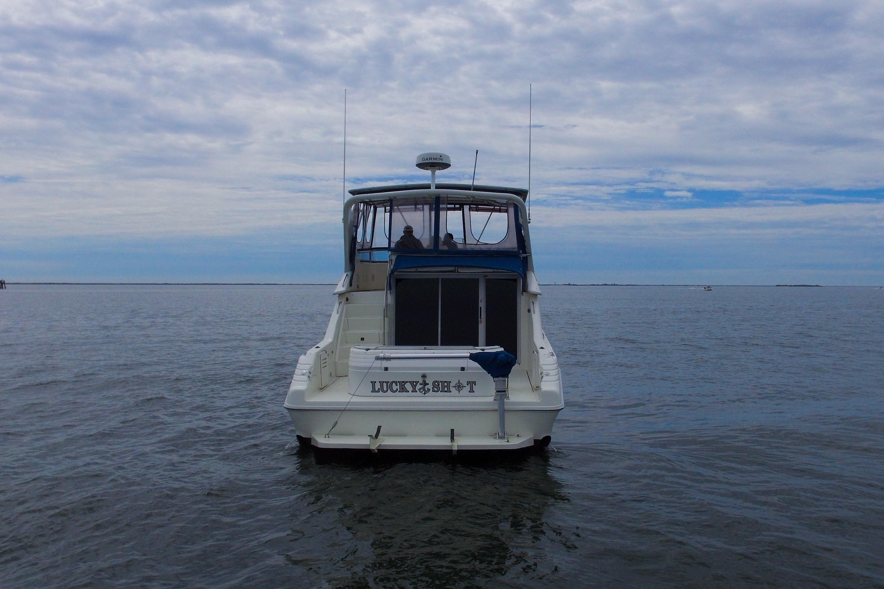 1993 Sea Ray 440 Express Bridge yacht on open water under cloudy sky.