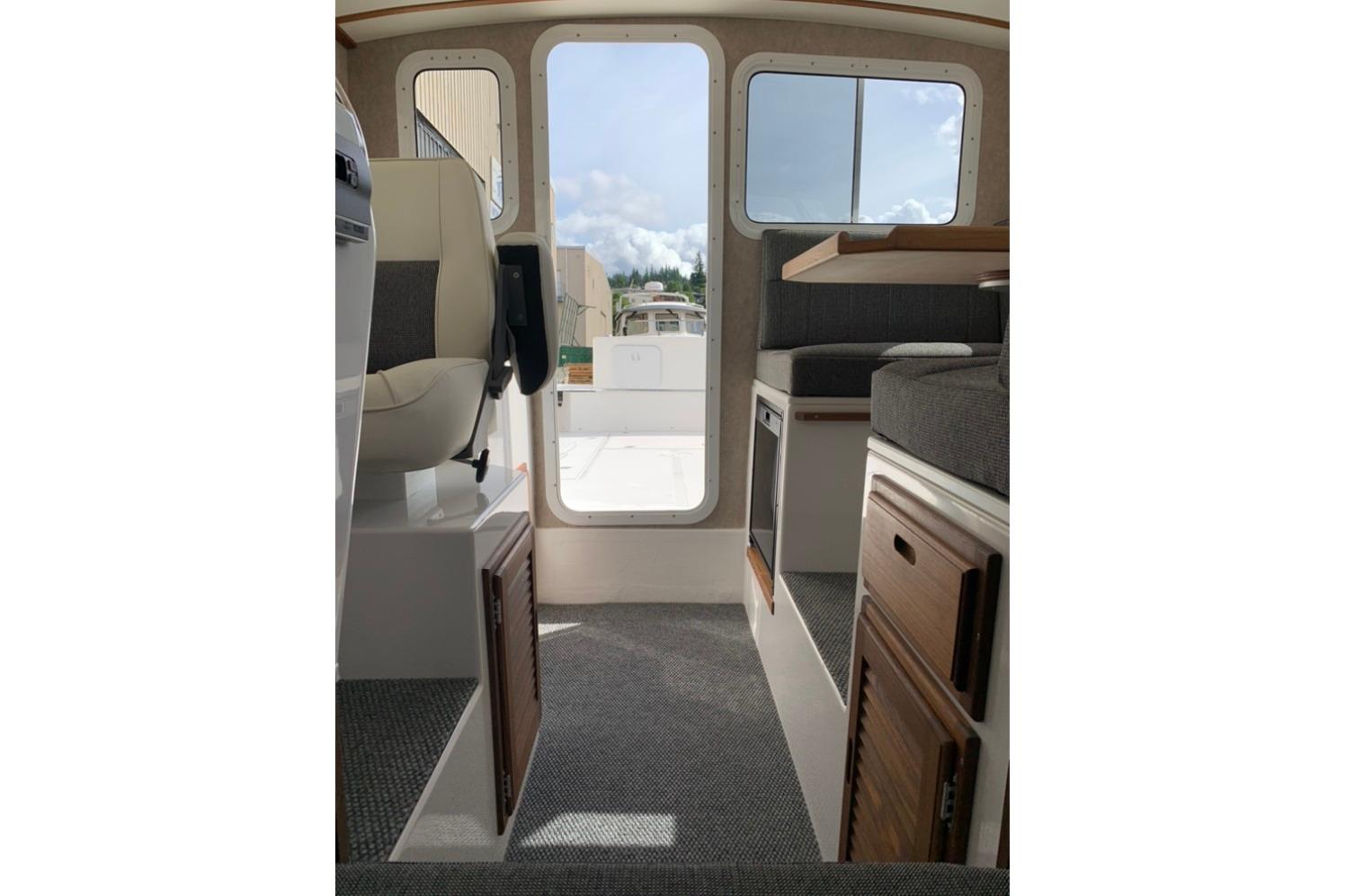 Interior view of 2026 Sea Sport Kenai 2600 boat, featuring seating and storage.