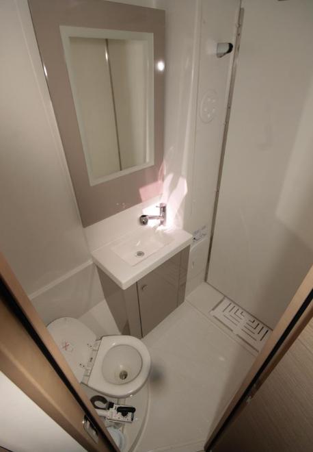 Modern bathroom in 2023 Fountaine Pajot Catamaran Astrea 42, featuring sleek fixtures and compact design.