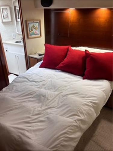 1986 Egg Harbor 60 Sportfisherman cabin with bed, red pillows, and adjacent bathroom.