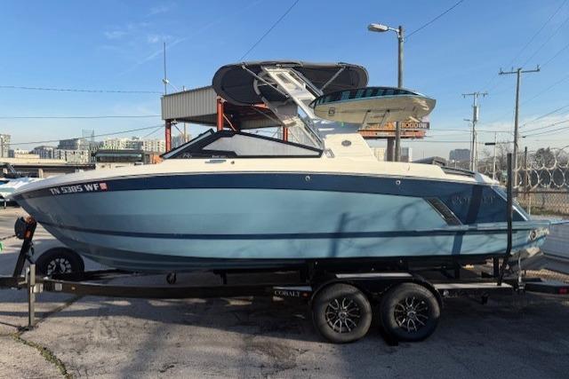 2023 Cobalt R6 Surf boat on trailer, blue and white design, parked outdoors.