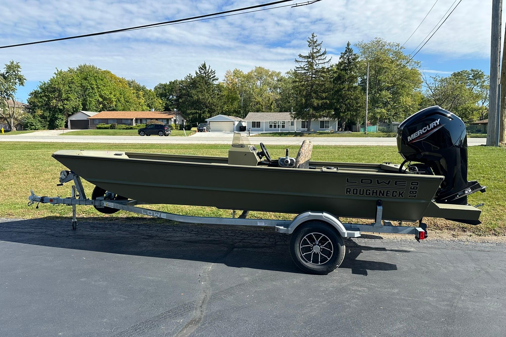 2026 Lowe Roughneck 1860SC boat on trailer, parked outdoors, with Mercury outboard motor.