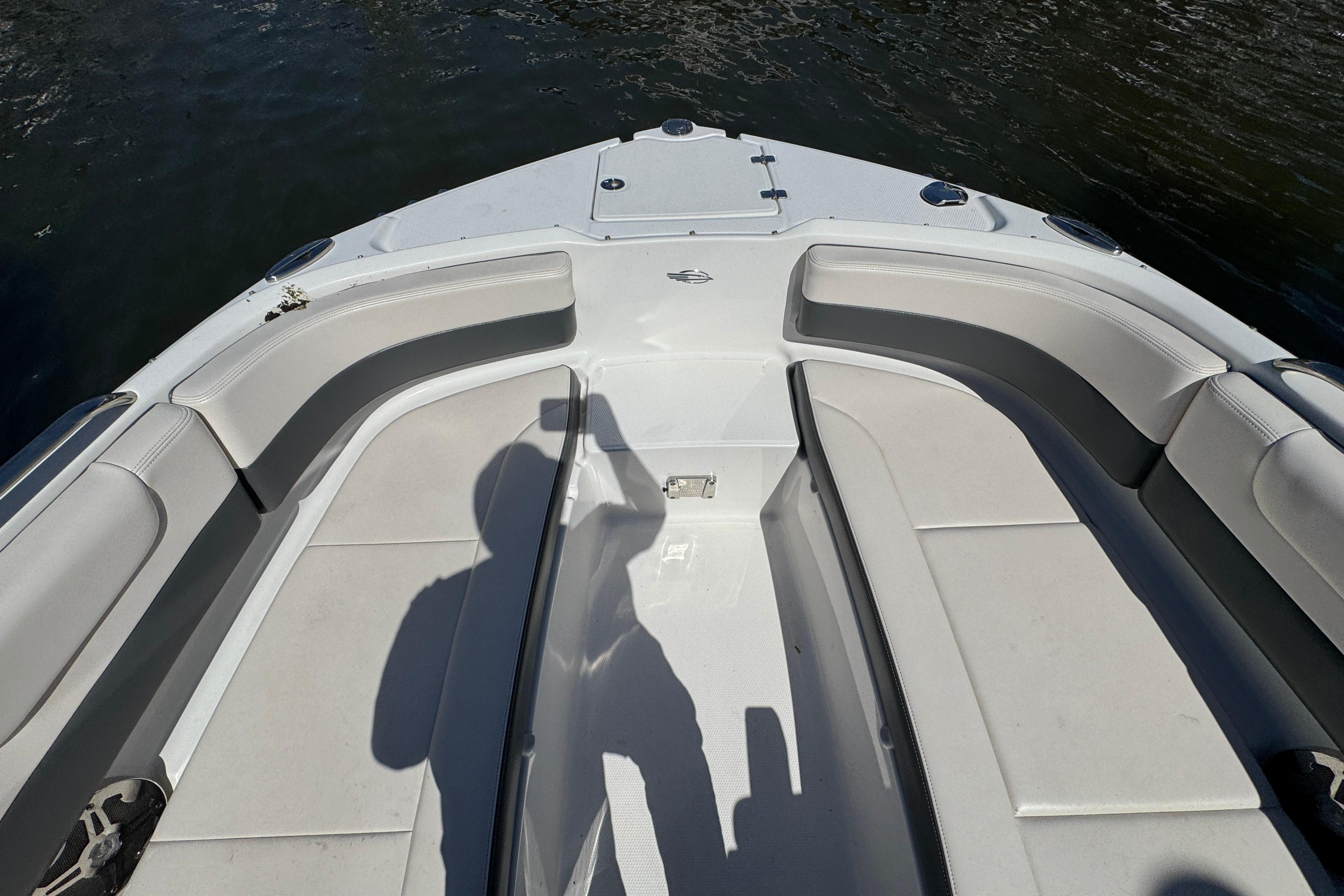 Bow seating area of 2018 Chaparral 250 Suncoast boat, featuring comfortable white cushions.