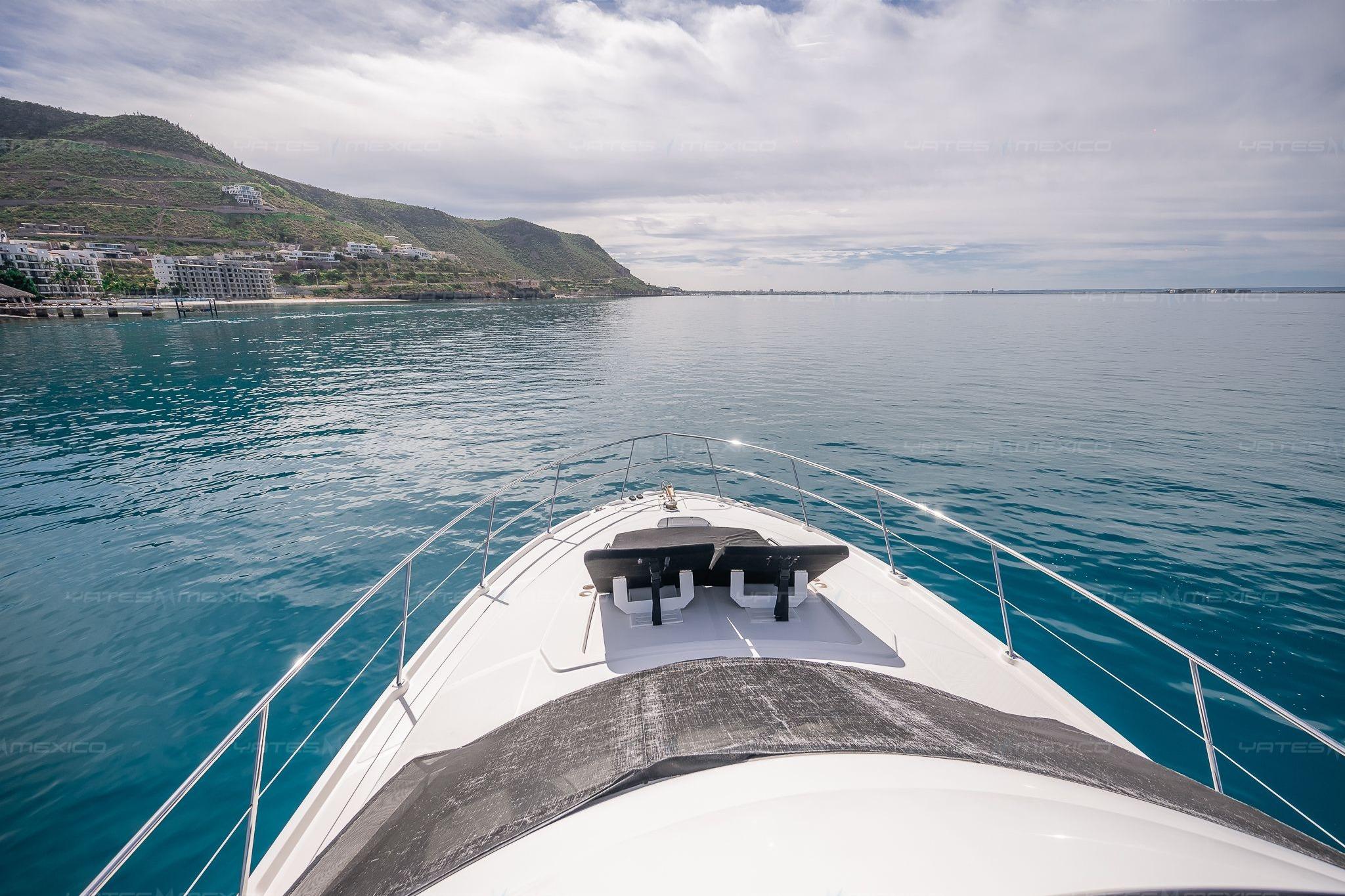 Bow view of 2008 Sea Ray 480 Sedan Bridge cruising on calm waters near scenic coastline.