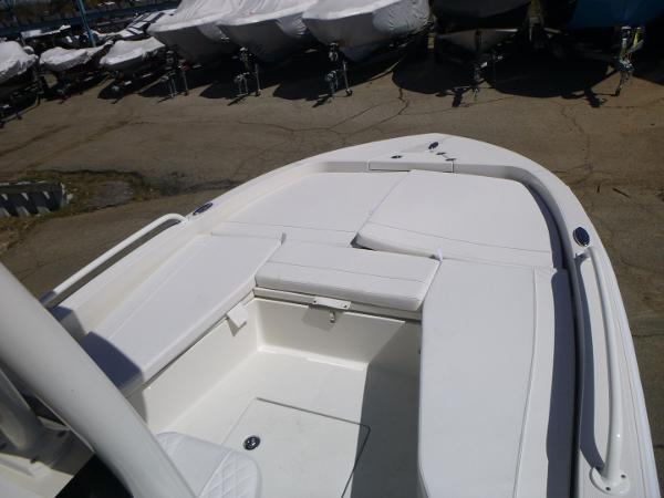 2024 Ranger 2360 Bay boat, white deck, docked with covered boats in background.