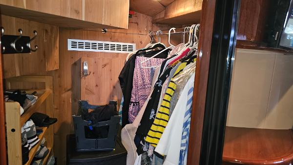 Clothing storage area inside 2005 Neptunus 56 Flybridge yacht with wooden interior.