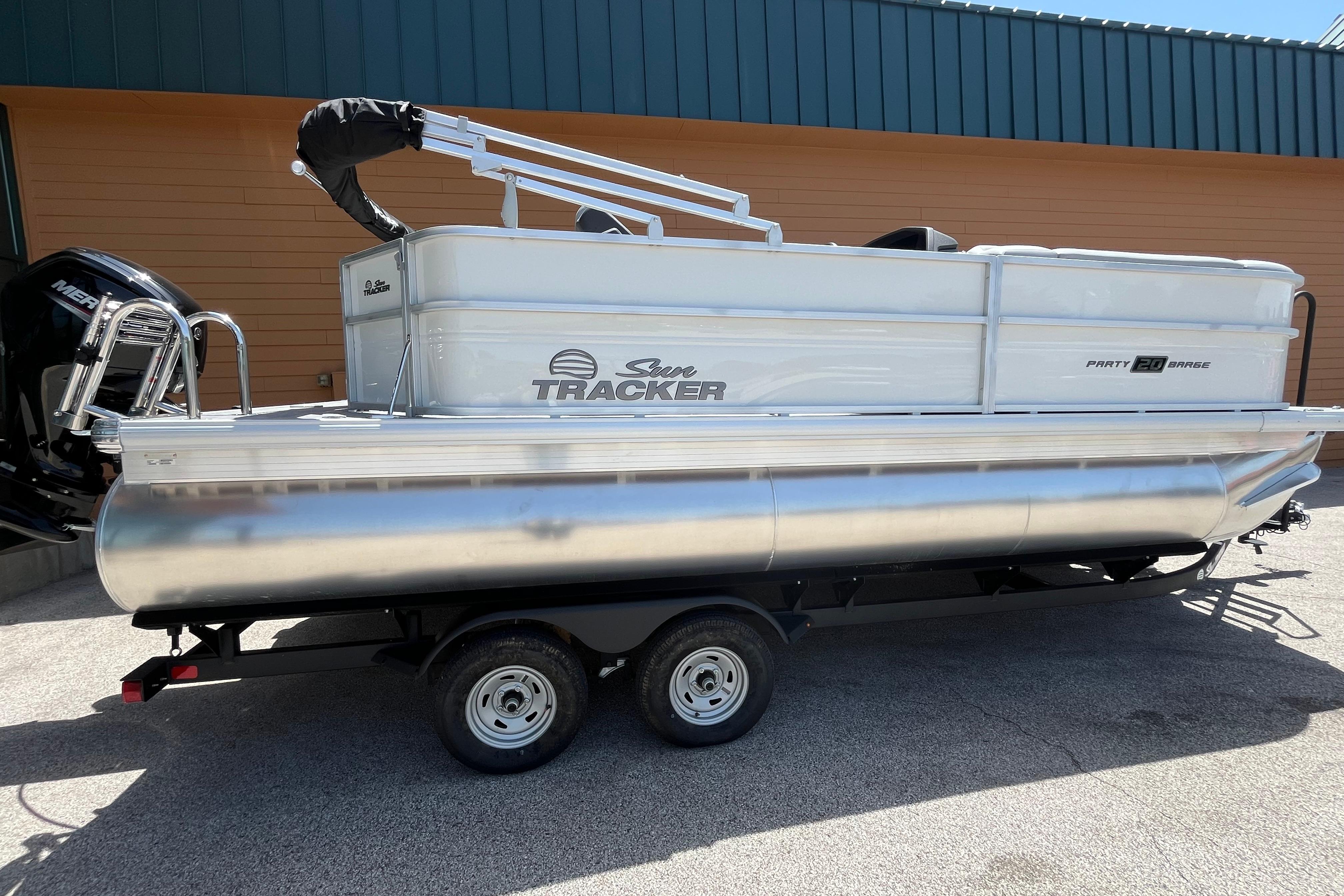2026 Sun Tracker Party Barge 20 DLX pontoon boat on trailer, parked outdoors.