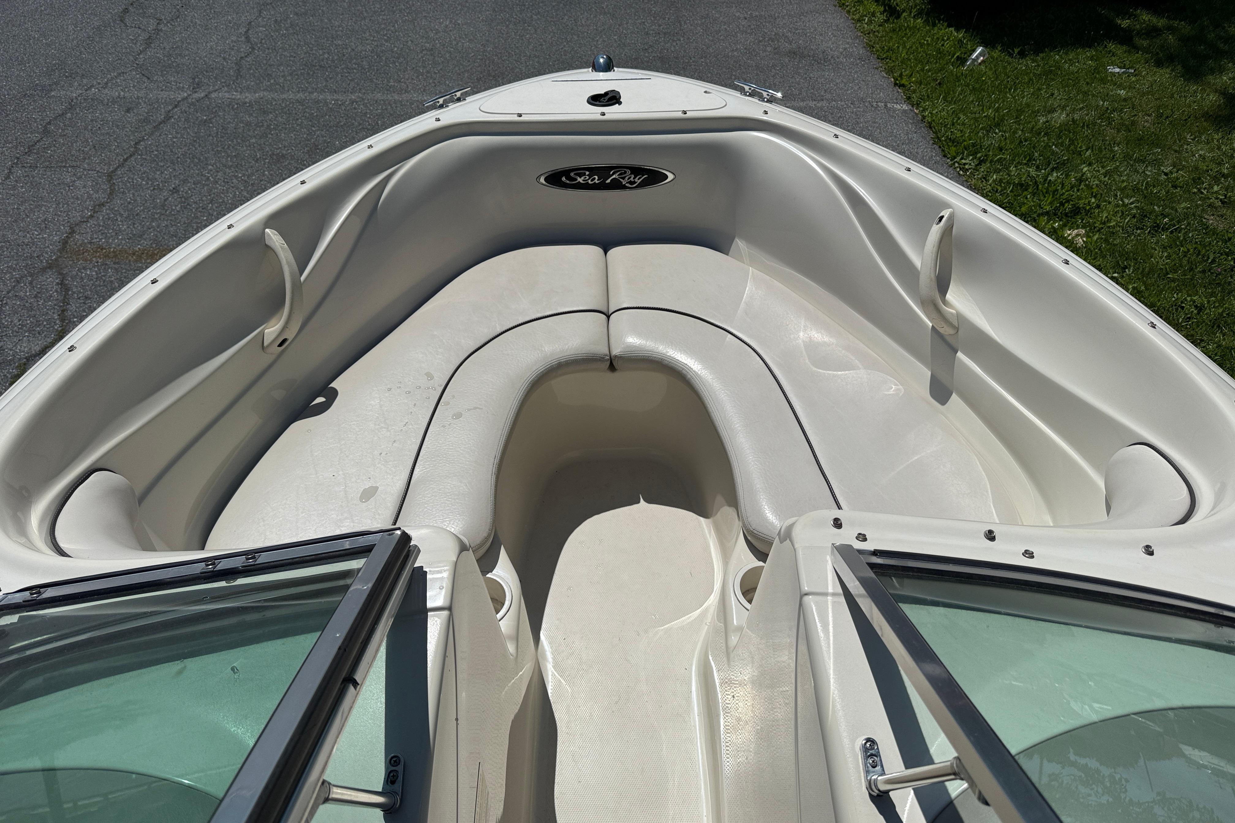2003 Sea Ray 182 Bow Rider boat interior with white seating and open windshield.