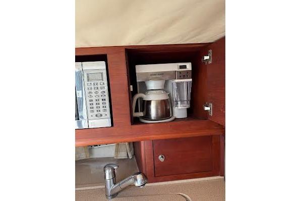 2006 Chris Craft Corsair Heritage kitchen with microwave, coffee maker, and wooden cabinetry.