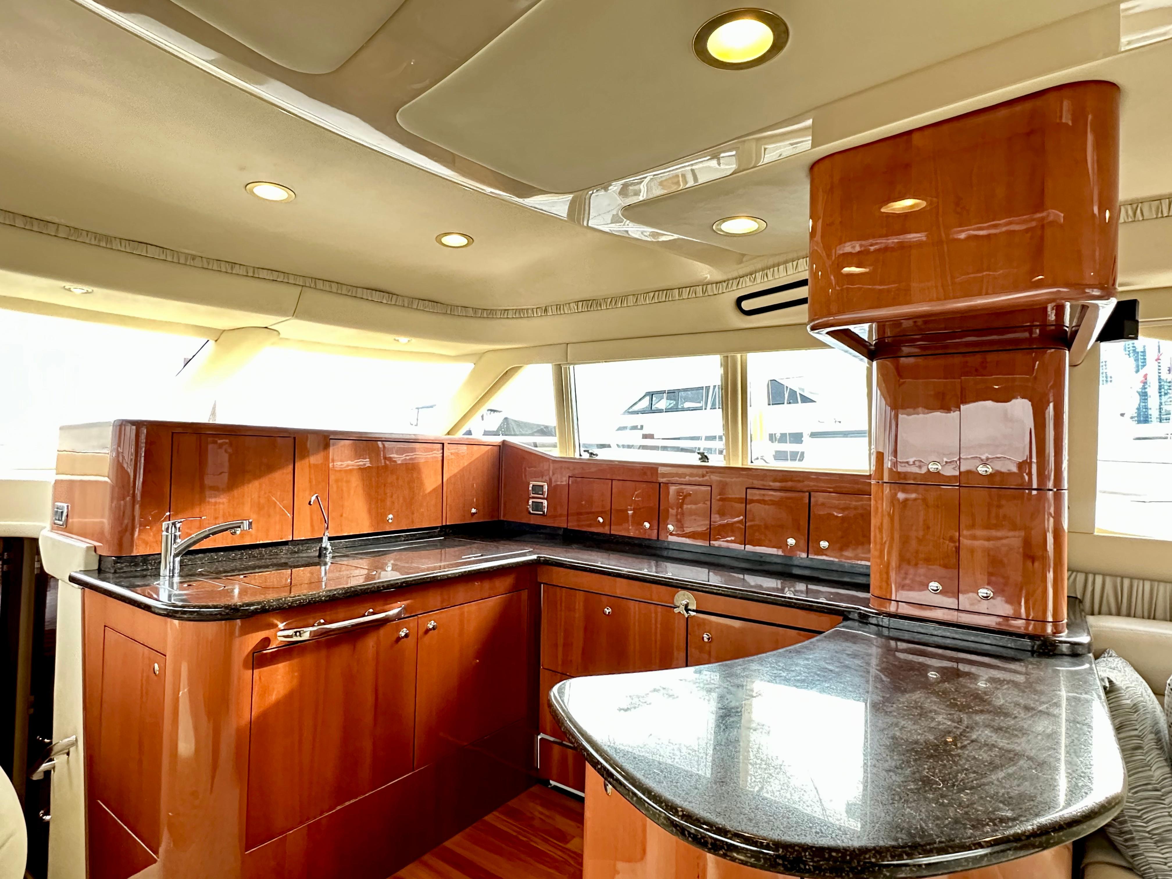 Luxurious kitchen interior of 2002 Sea Ray 560 Sedan Bridge yacht with wood cabinetry.