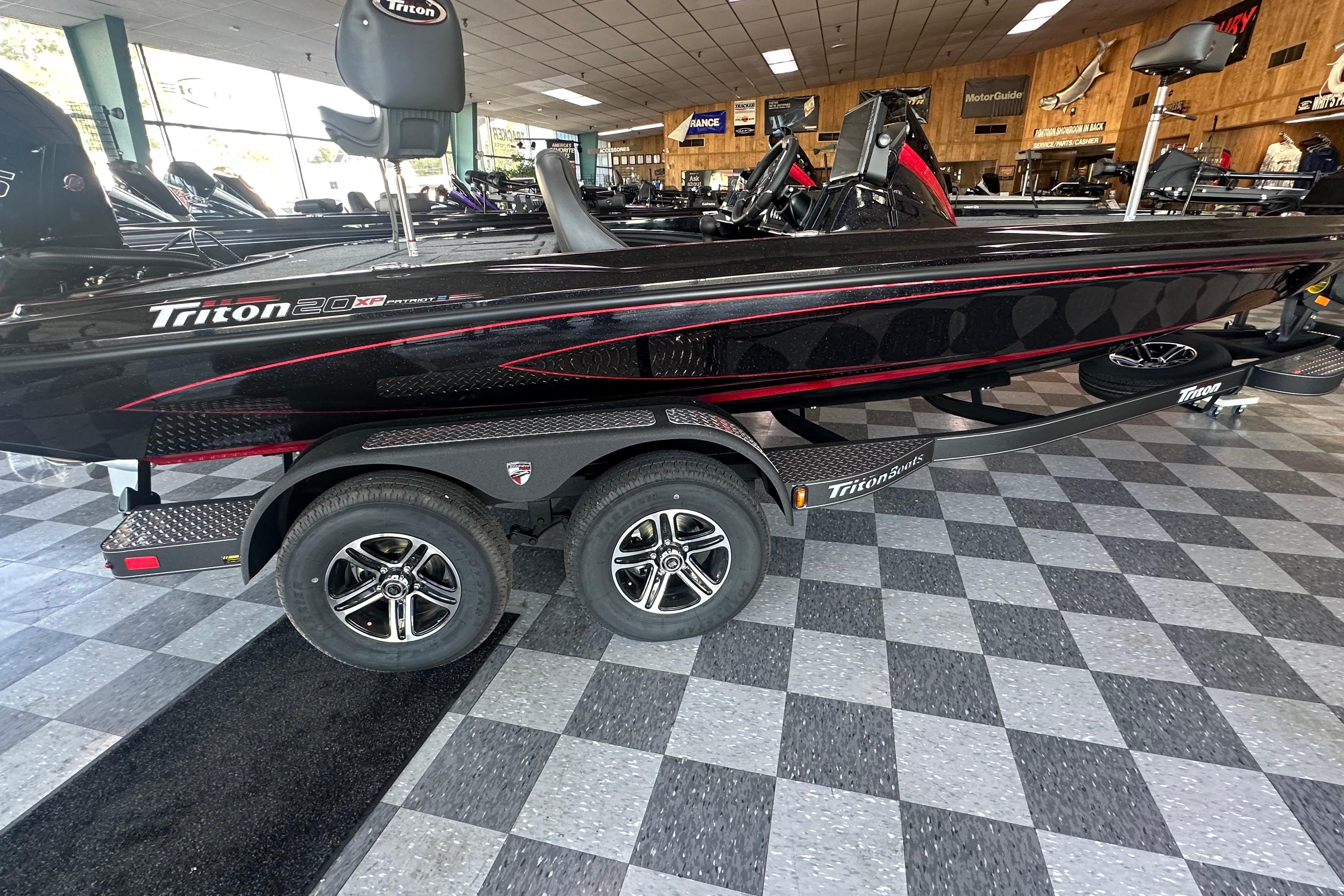 2026 Triton 20XP Patriot boat displayed in showroom with checkered floor.