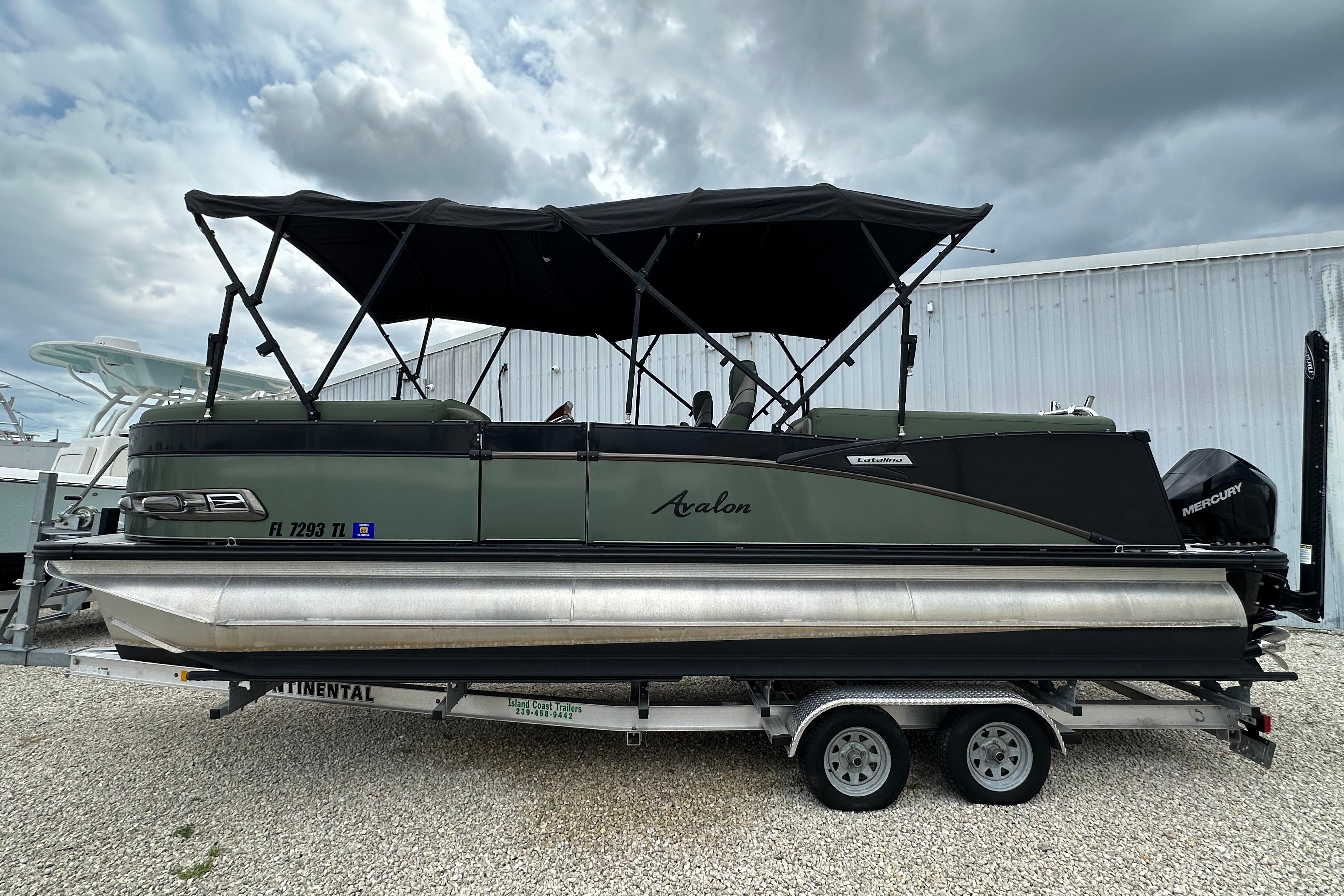 2023 Avalon Catalina Quad Lounge pontoon boat on trailer, under cloudy sky.