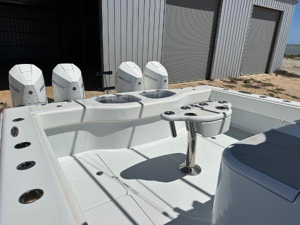 2022 Freeman 42LR boat with Mercury engines, docked near a metal building.