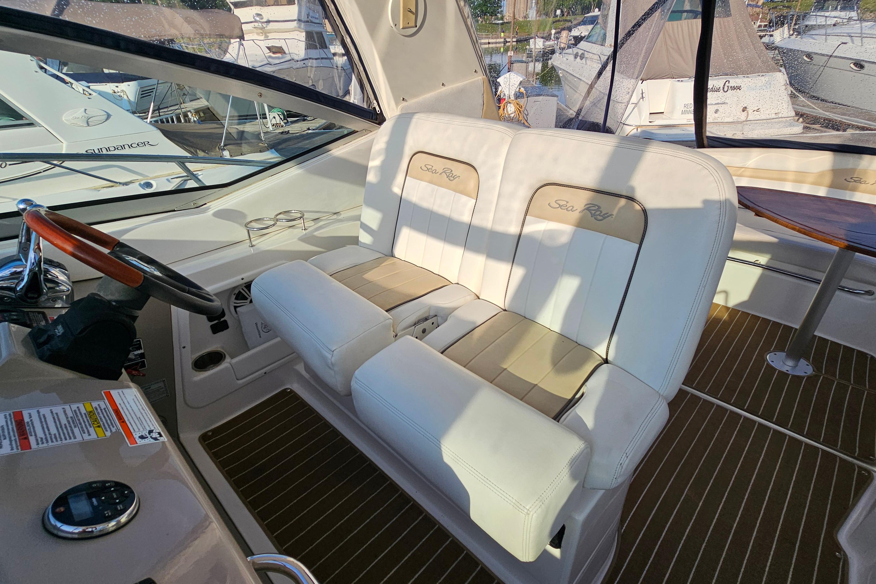 Interior of a 2008 Sea Ray Sundancer 350 boat with white seating and wooden accents.