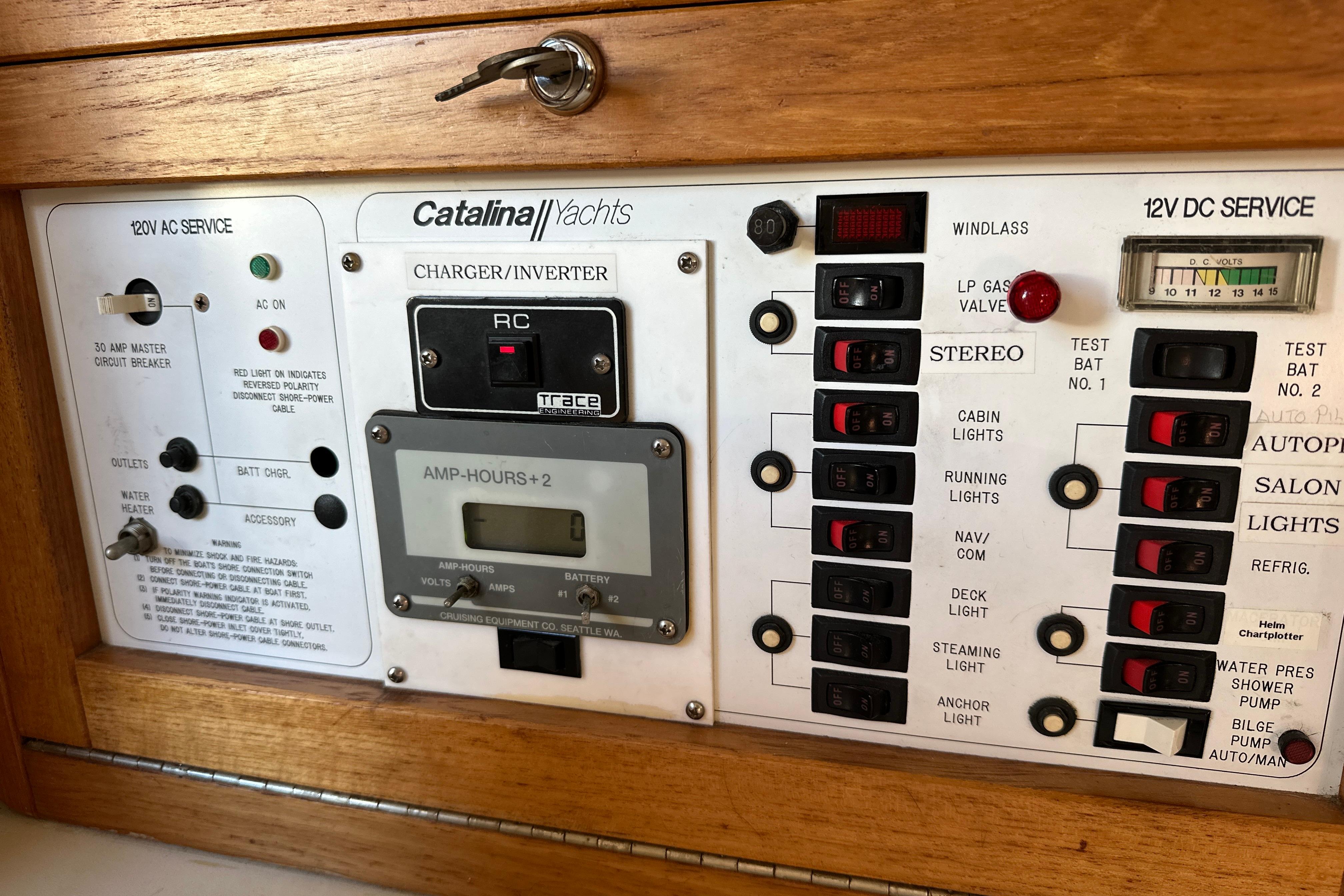 Electrical control panel of a 1995 Catalina 320 yacht with various switches and indicators.