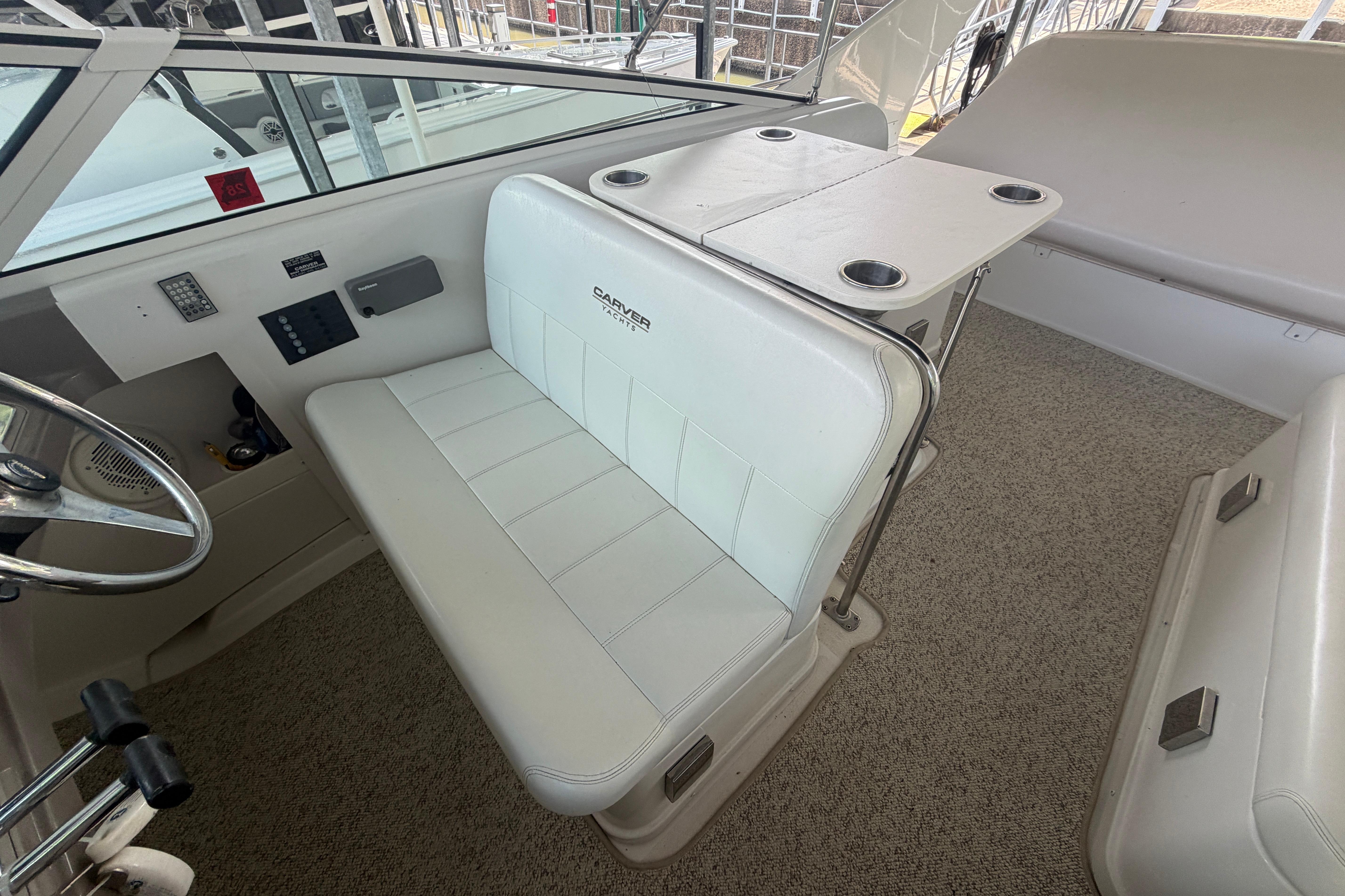 Interior of 2000 Carver 350 Mariner yacht with white seating and control panel.