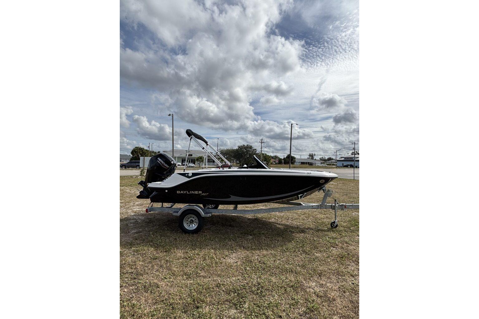2025 Bayliner Element M17 boat on trailer under cloudy sky.