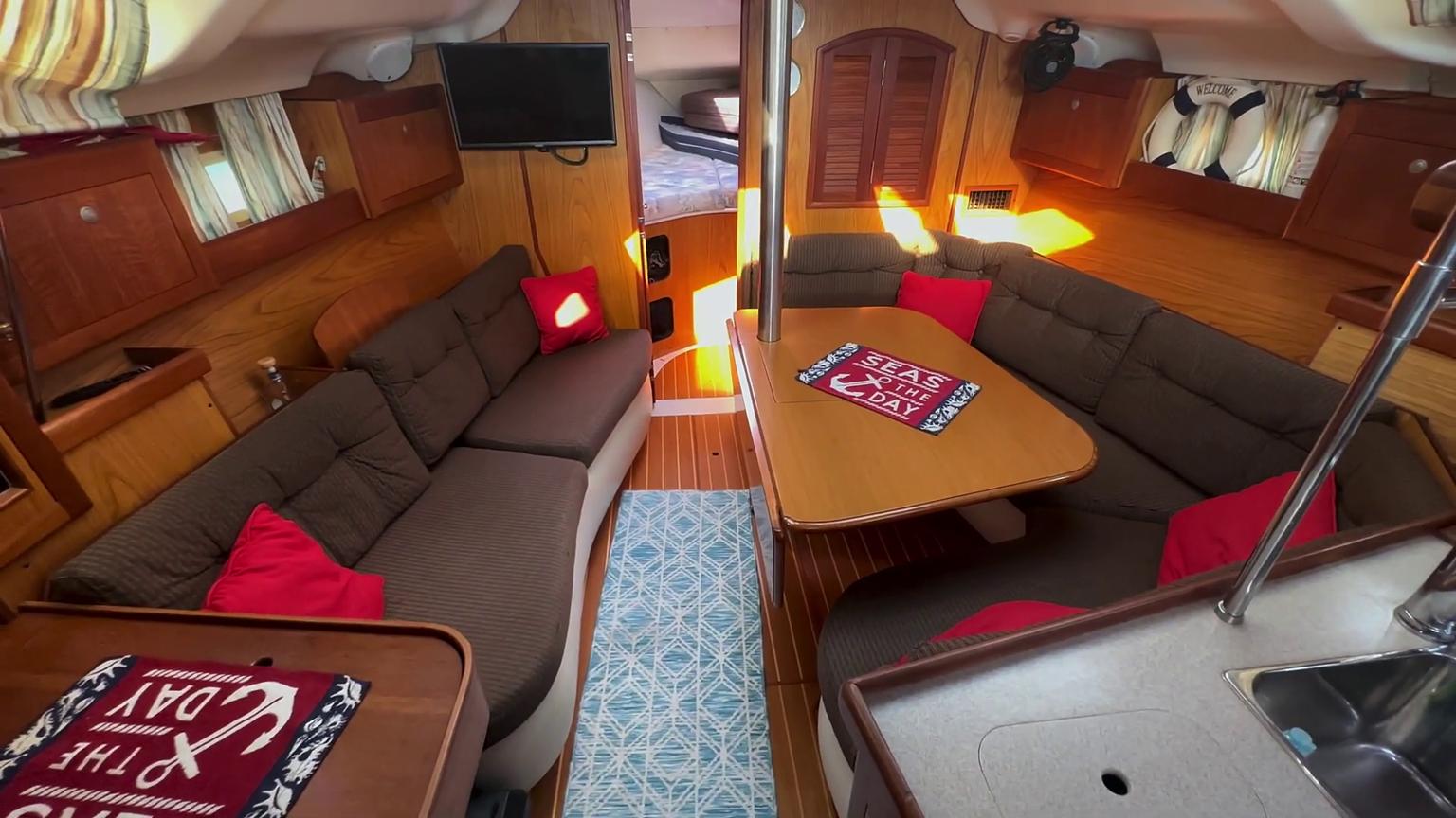 Interior of a 2001 Hunter 380 sailboat with cozy seating and nautical decor.