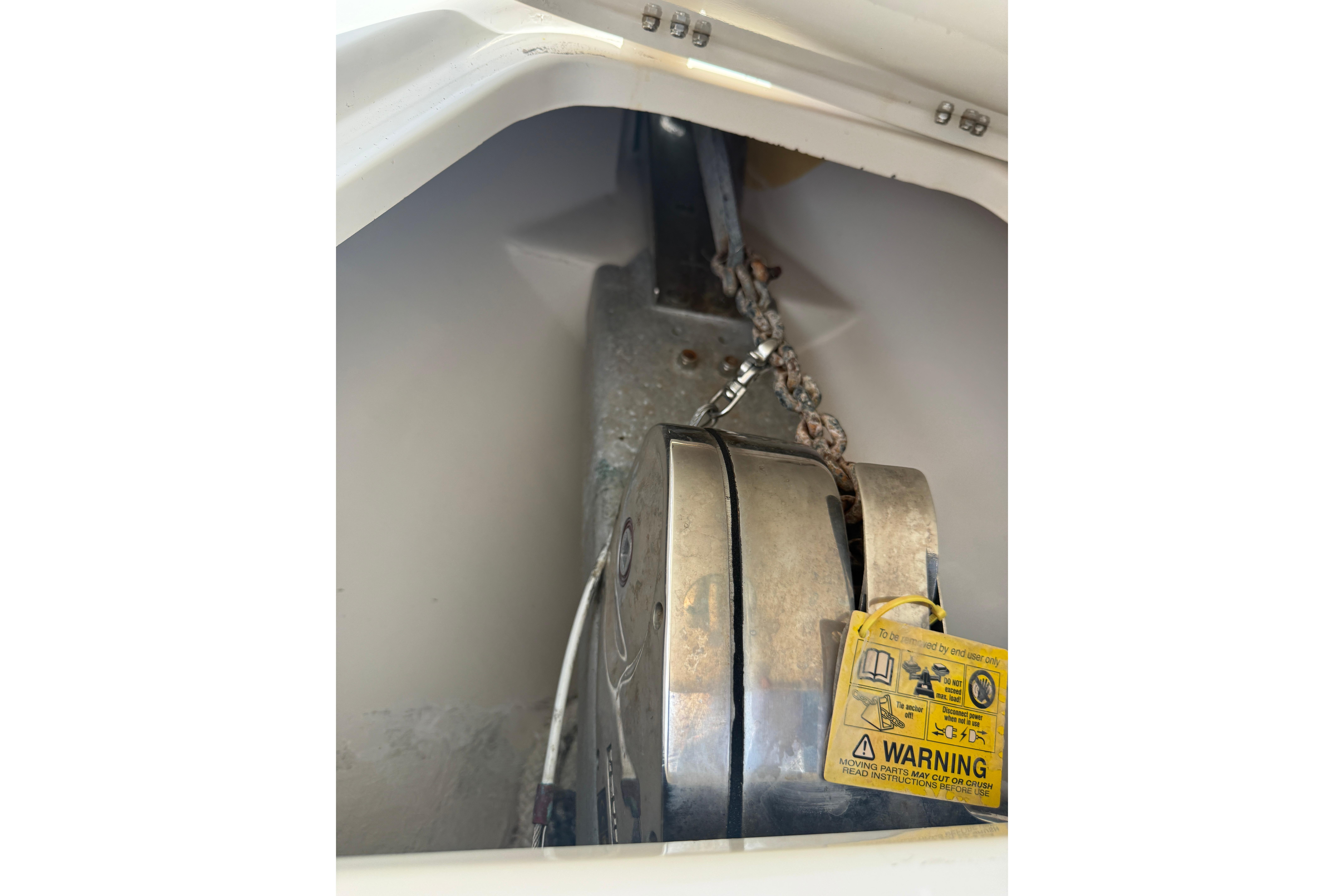 Anchor chain mechanism in a 2015 Blackwood 27 boat, featuring a warning label.