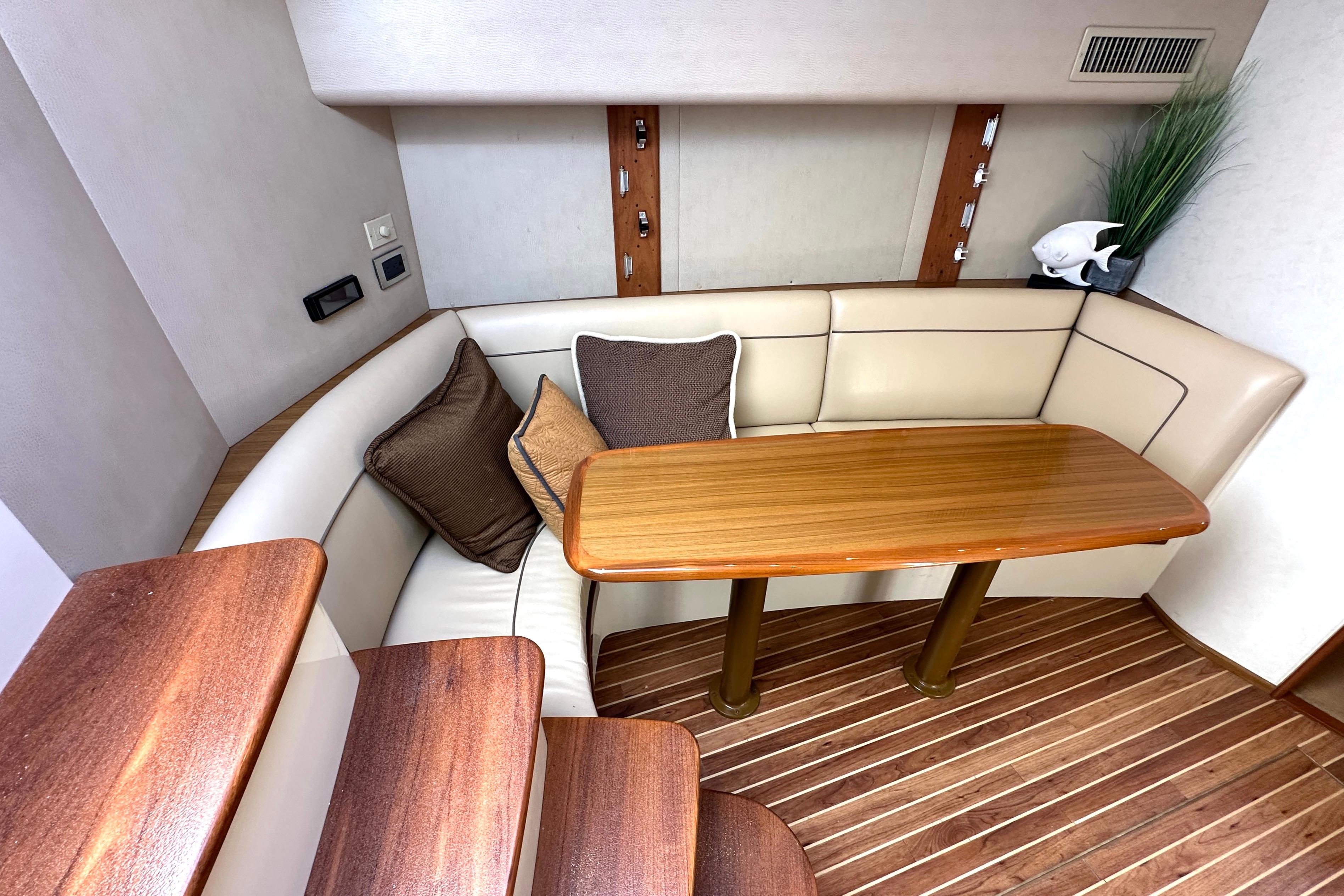 Interior of 2012 Viking 42 Open yacht with wooden table and cushioned seating.