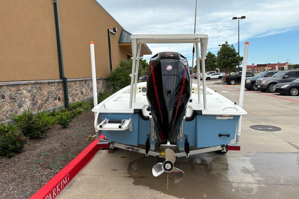 2026 Mako 18 Pro Skiff boat with outboard motor in parking lot.