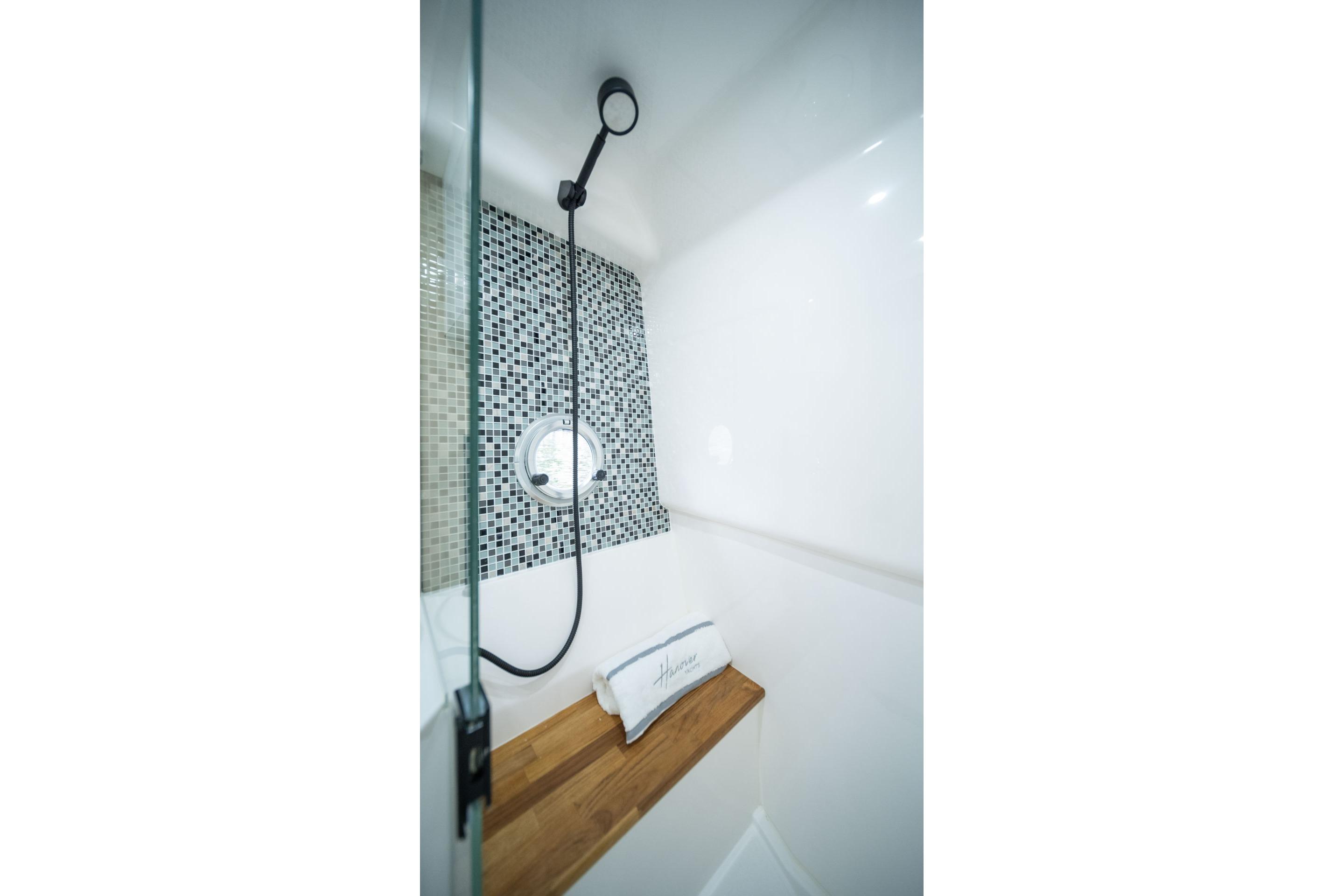 Modern shower with mosaic tiles and wooden bench in Hanover 387, 2026 model.