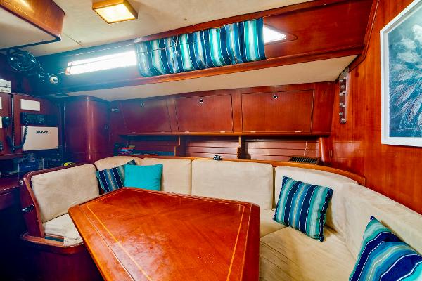 Interior of 1989 Concordia 52 yacht with wooden furnishings and cozy seating area.