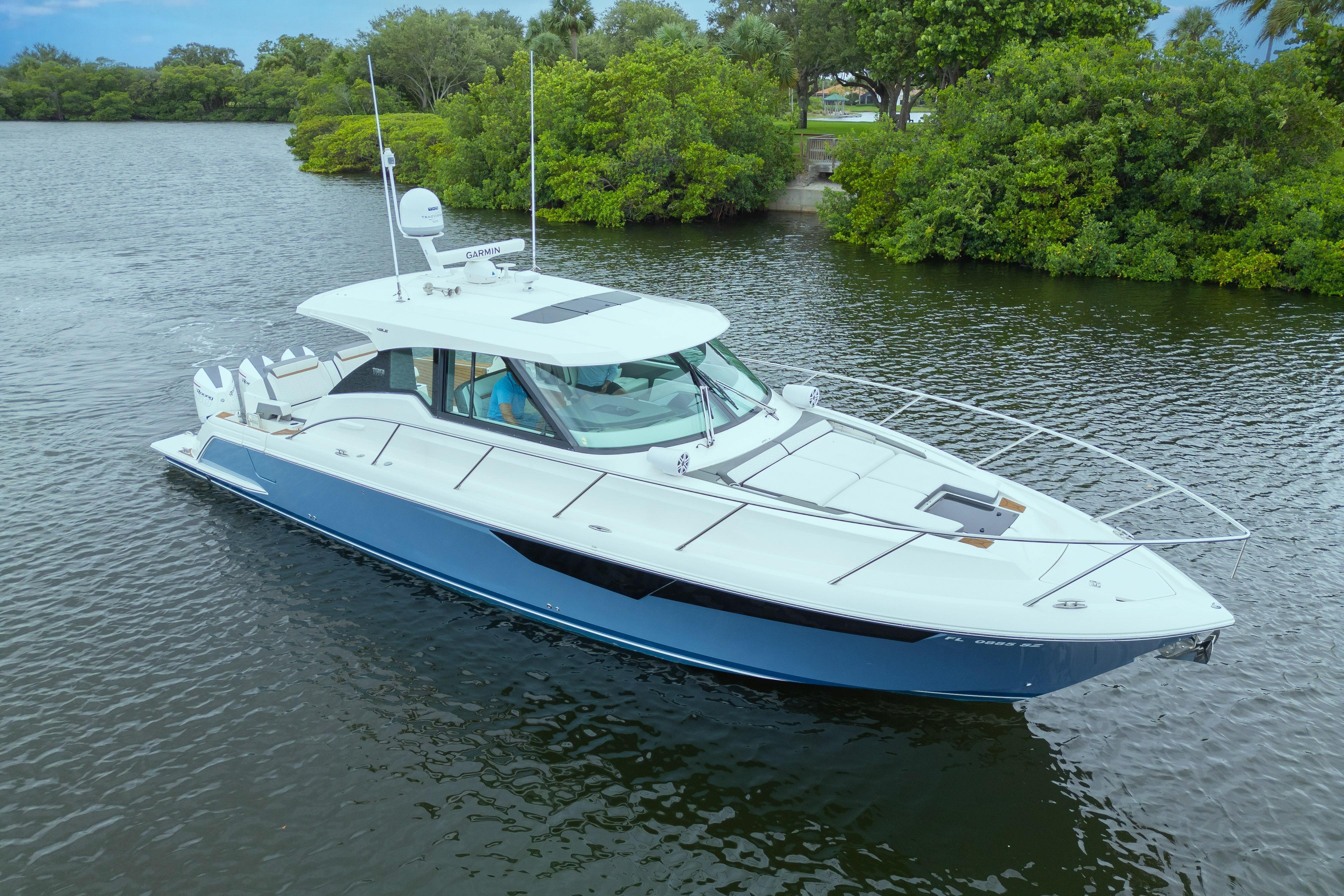 2021 Tiara Sport 43 LE boat on a serene lake with lush greenery.