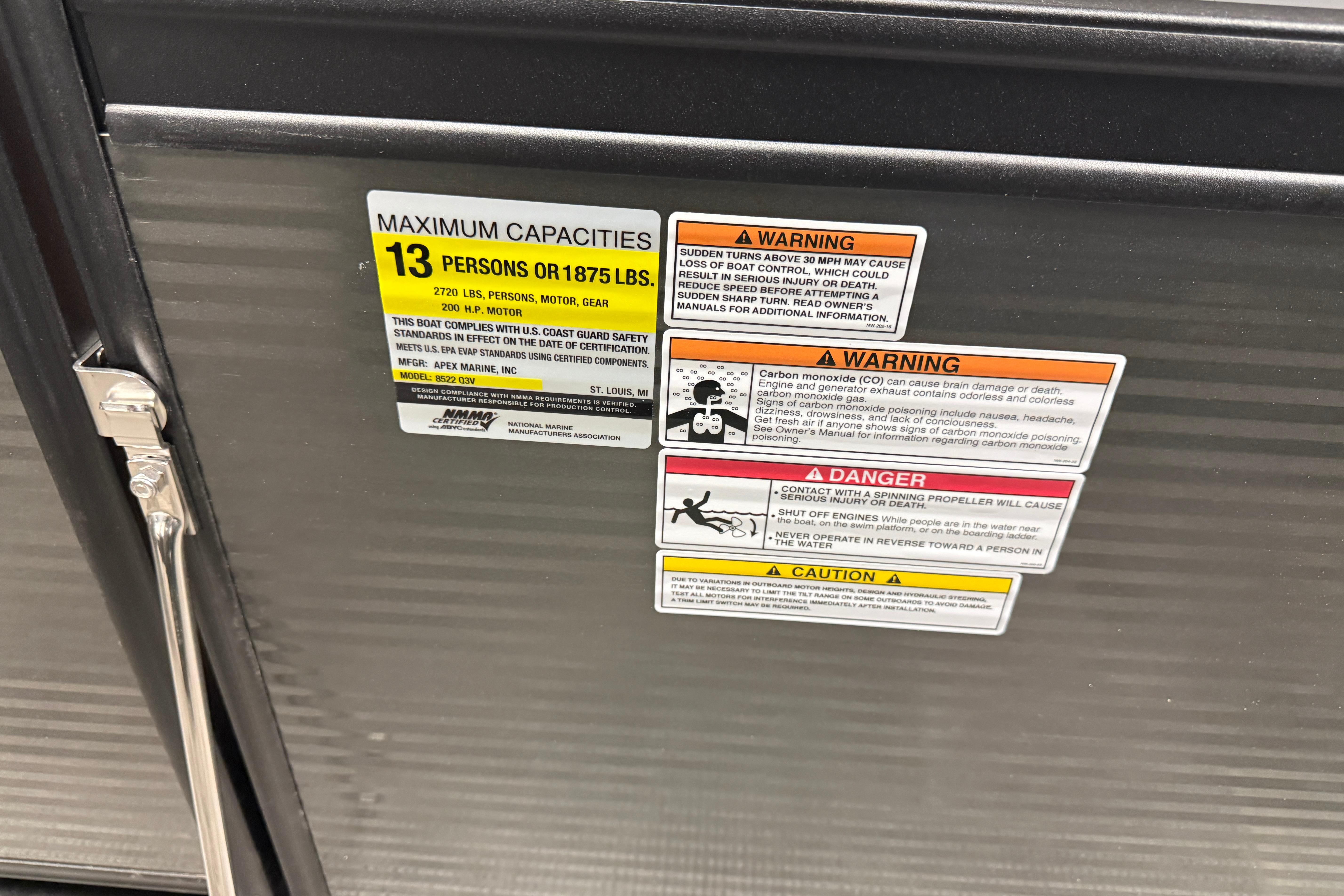 2026 Qwest M-Class 22 Pro Sport capacity and safety warning labels on boat panel.