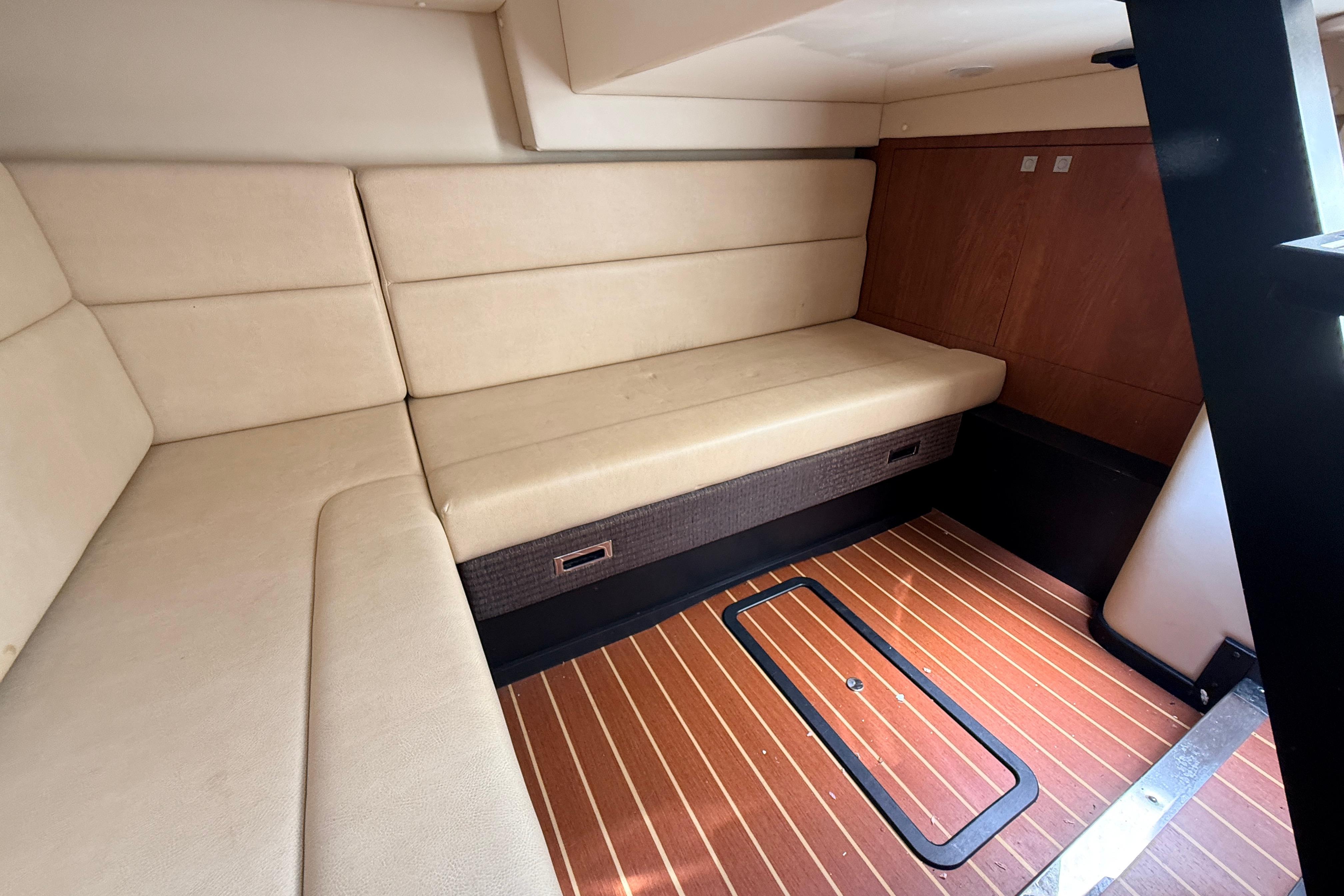 Interior of 2011 Monterey 320 Sport Yacht with beige seating and wooden flooring.